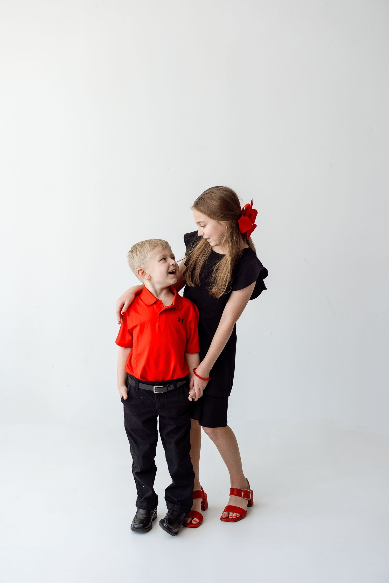 A sequence of three sweet moments between a child in red shirt and a person in a black dress against white background.