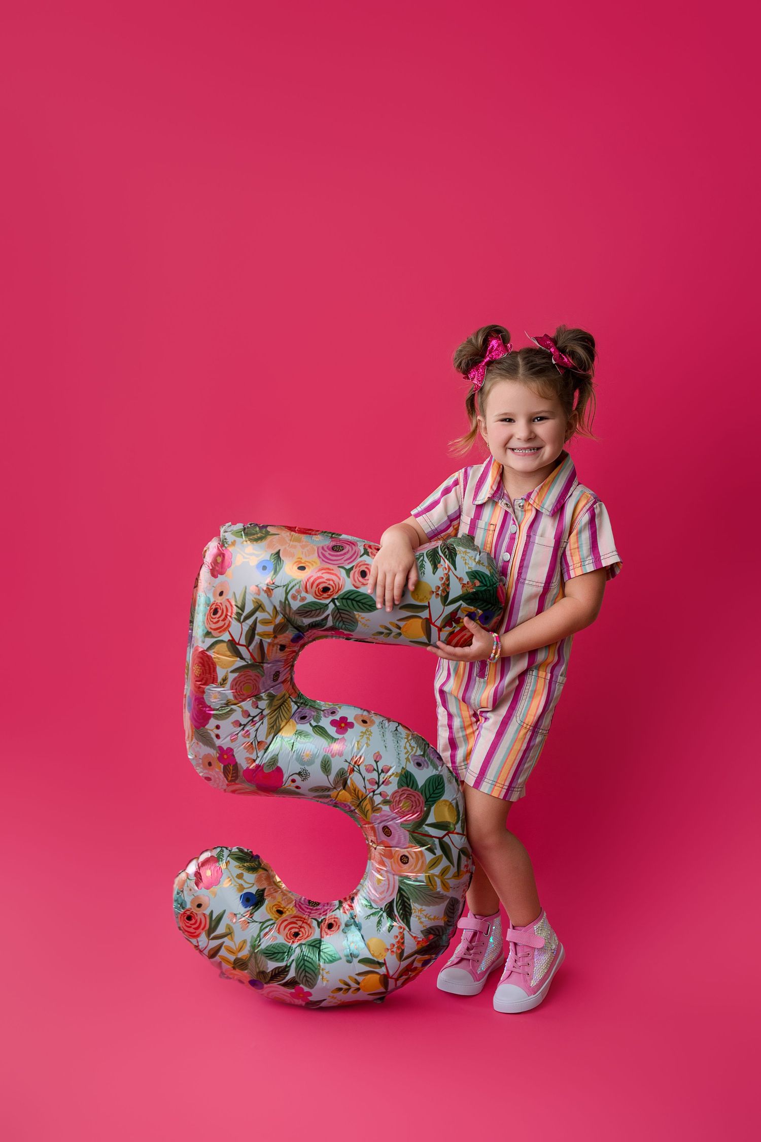 Colorful studio photos with a floral number 5 prop against a vibrant pink background.