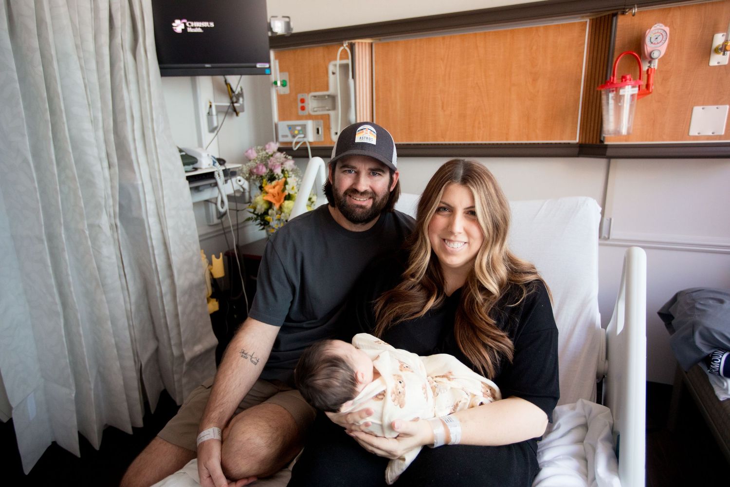 A couple sits together in a hospital room with their newborn baby during Fresh 48 session in Beaumont hospital.