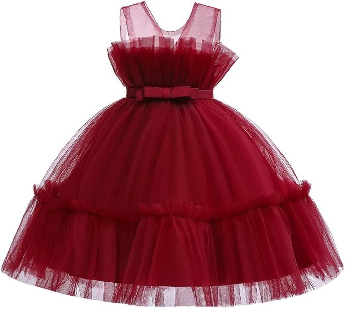 A row of burgundy red tulle party dresses with full skirts displayed in ascending size order.