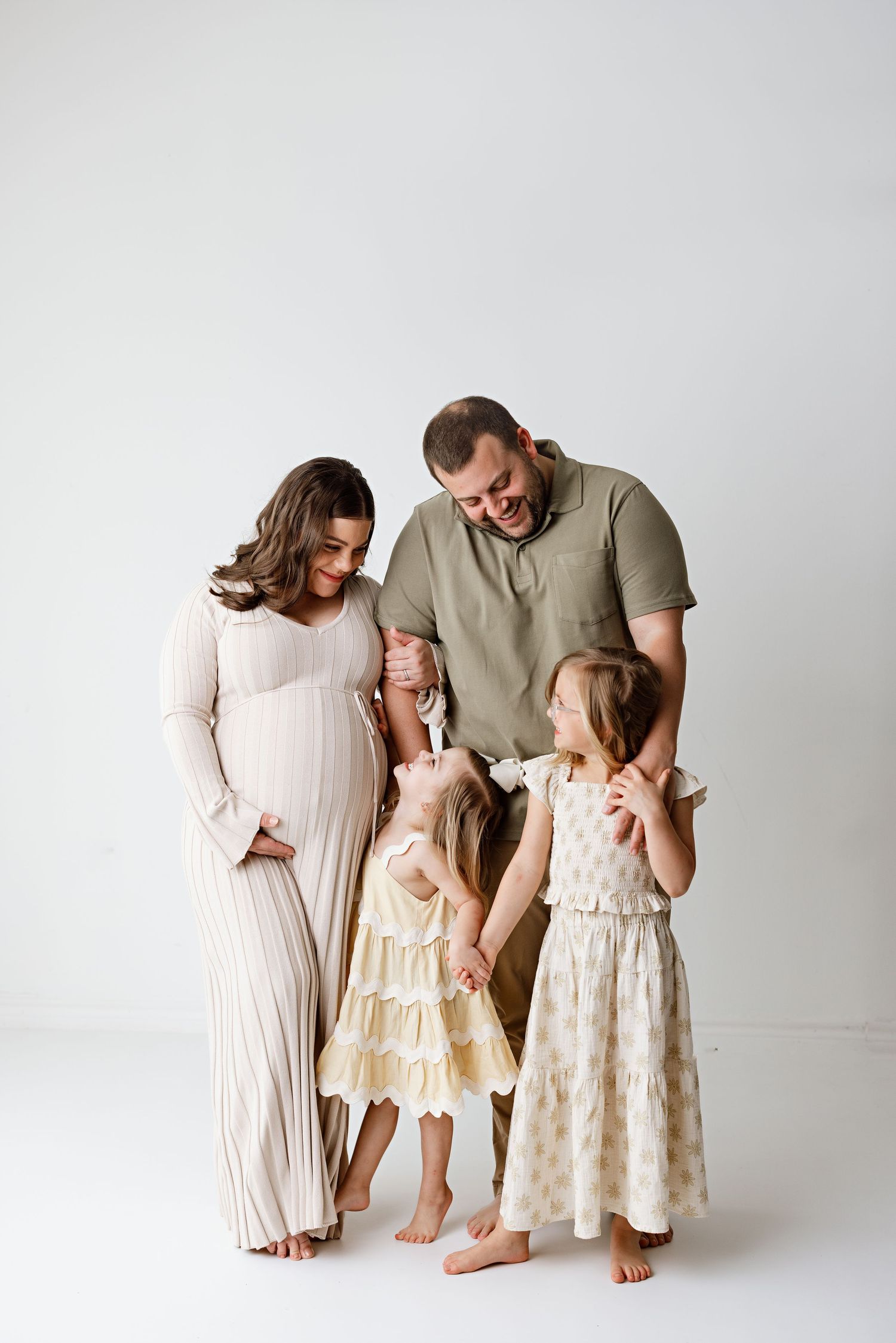 Family portrait with expecting mother and young children in neutral tones with Bree Elle Photography in Beaumont, TX.