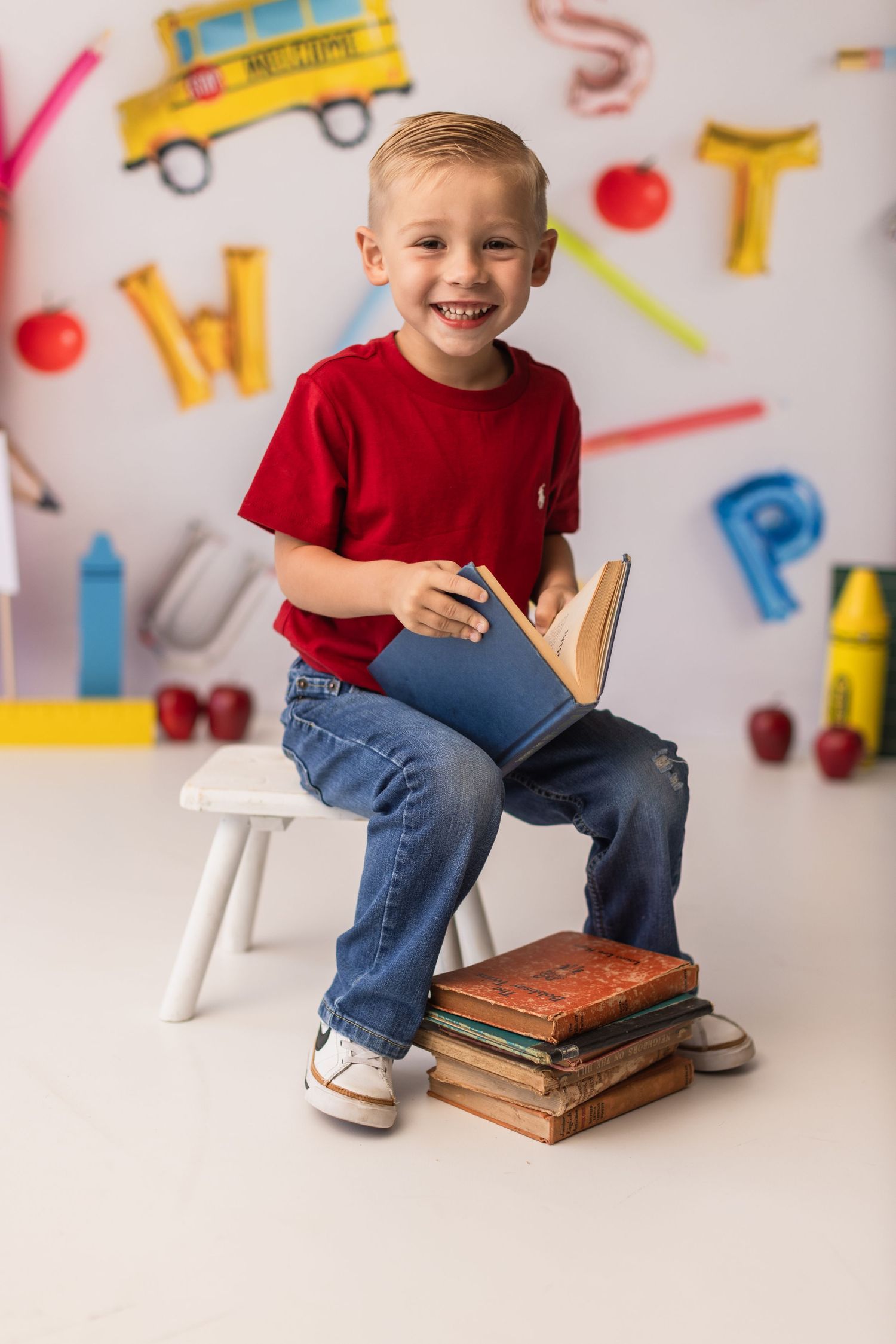 Educational themed portrait with school supplies and yellow bus decorations in background.