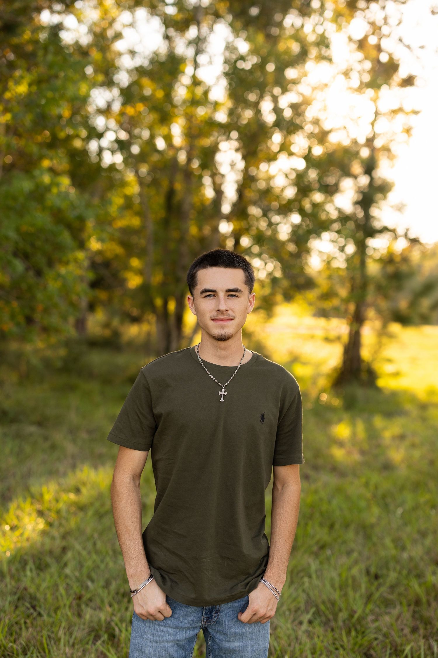 A series of outdoor portrait shots in a grassy field at golden hour with warm sunlit trees in the background.
