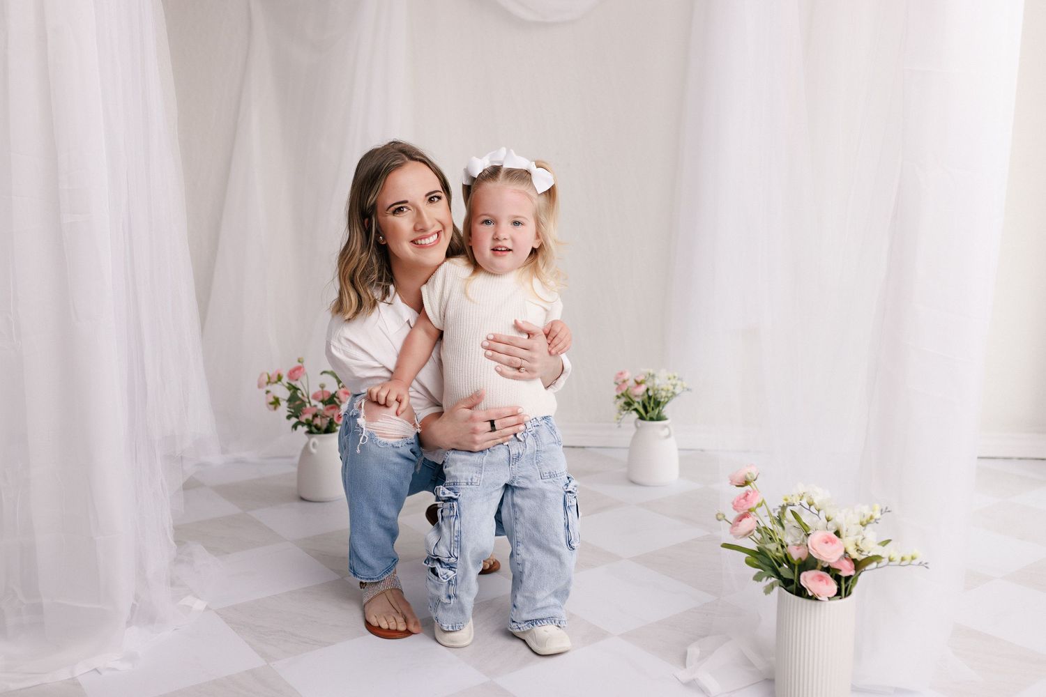 Parent and toddler in matching white tops and jeans during mommy and me session with Bree Elle Photography in Port Neches, TX.