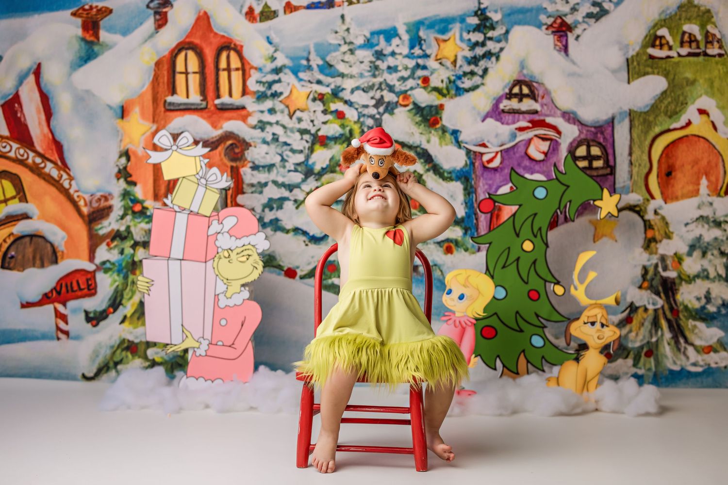 Whimsical winter wonderland backdrop with colorful cartoon houses and snow-covered trees.