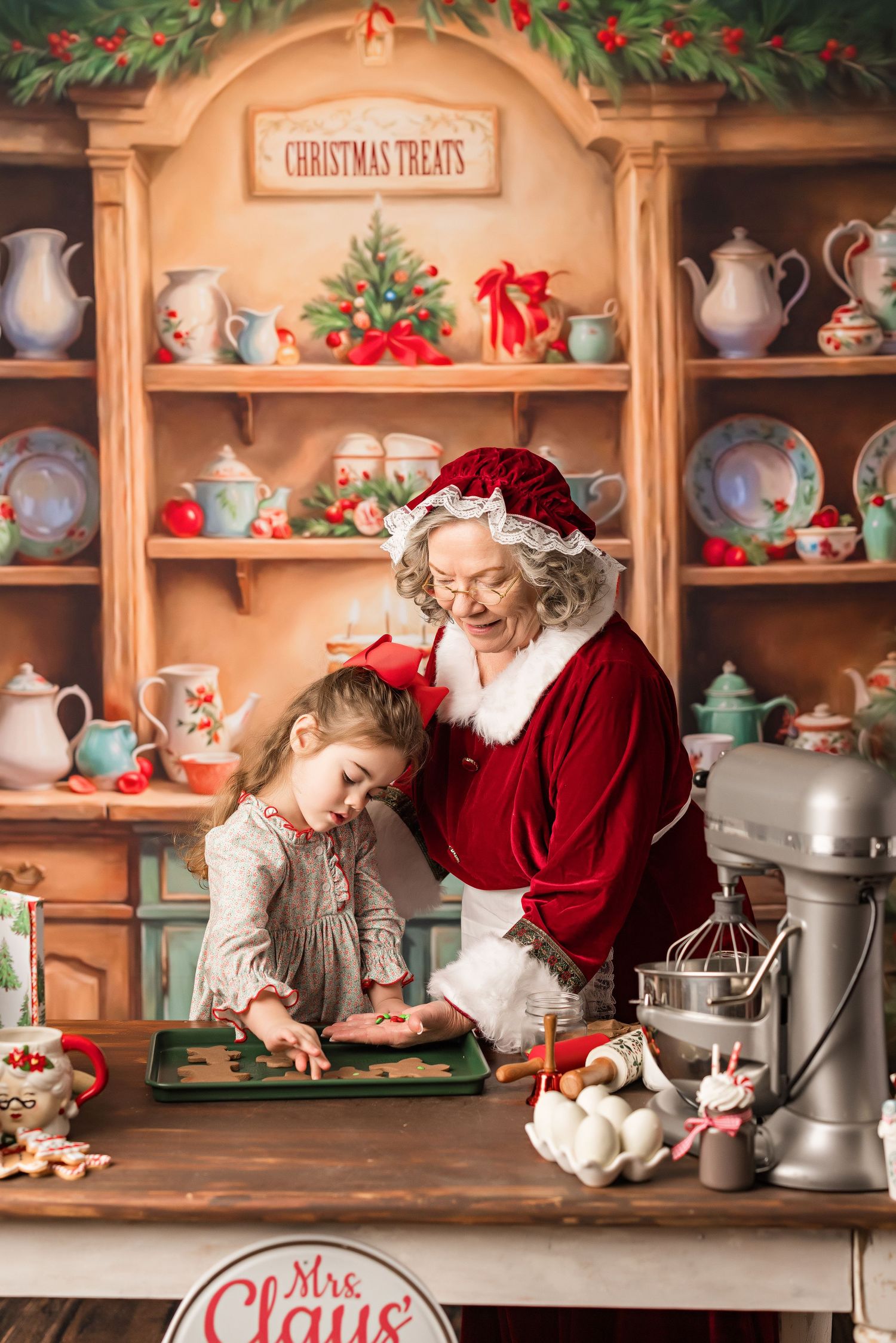 A cozy Christmas baking scene with vintage teapots and holiday decorations on display shelves.