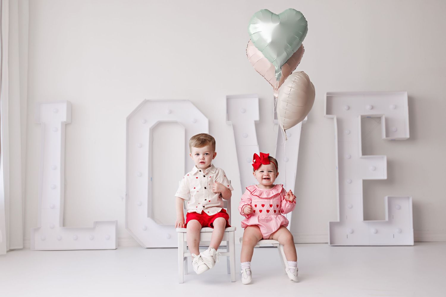 White block letters spelling LOVE with decorative hearts against neutral background.