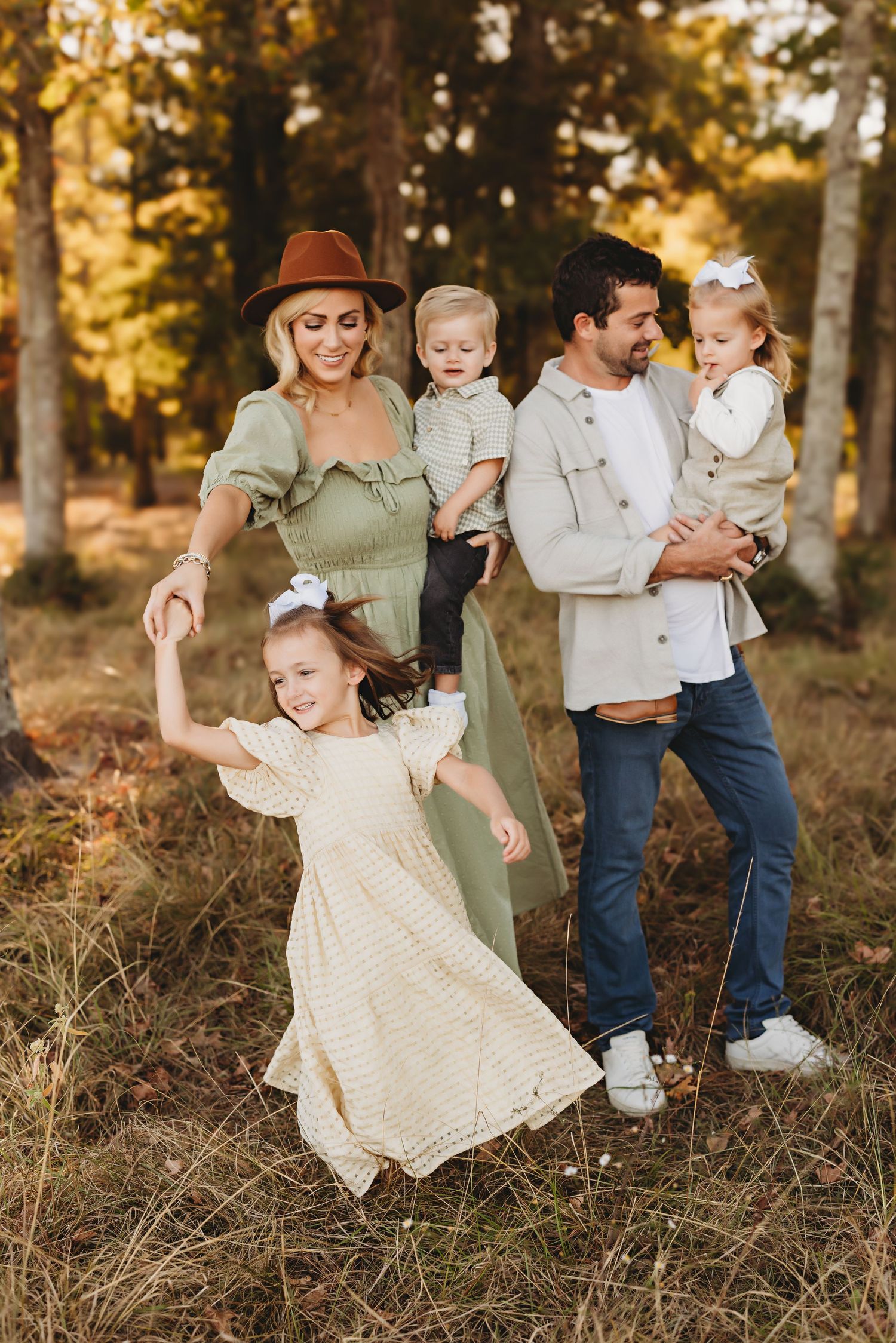 A family enjoying golden hour in the woods while sharing playful moments together.