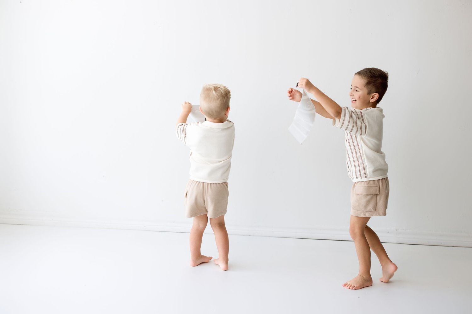 Four sequential images of a toddler wearing a diaper walking and playing against a white background.