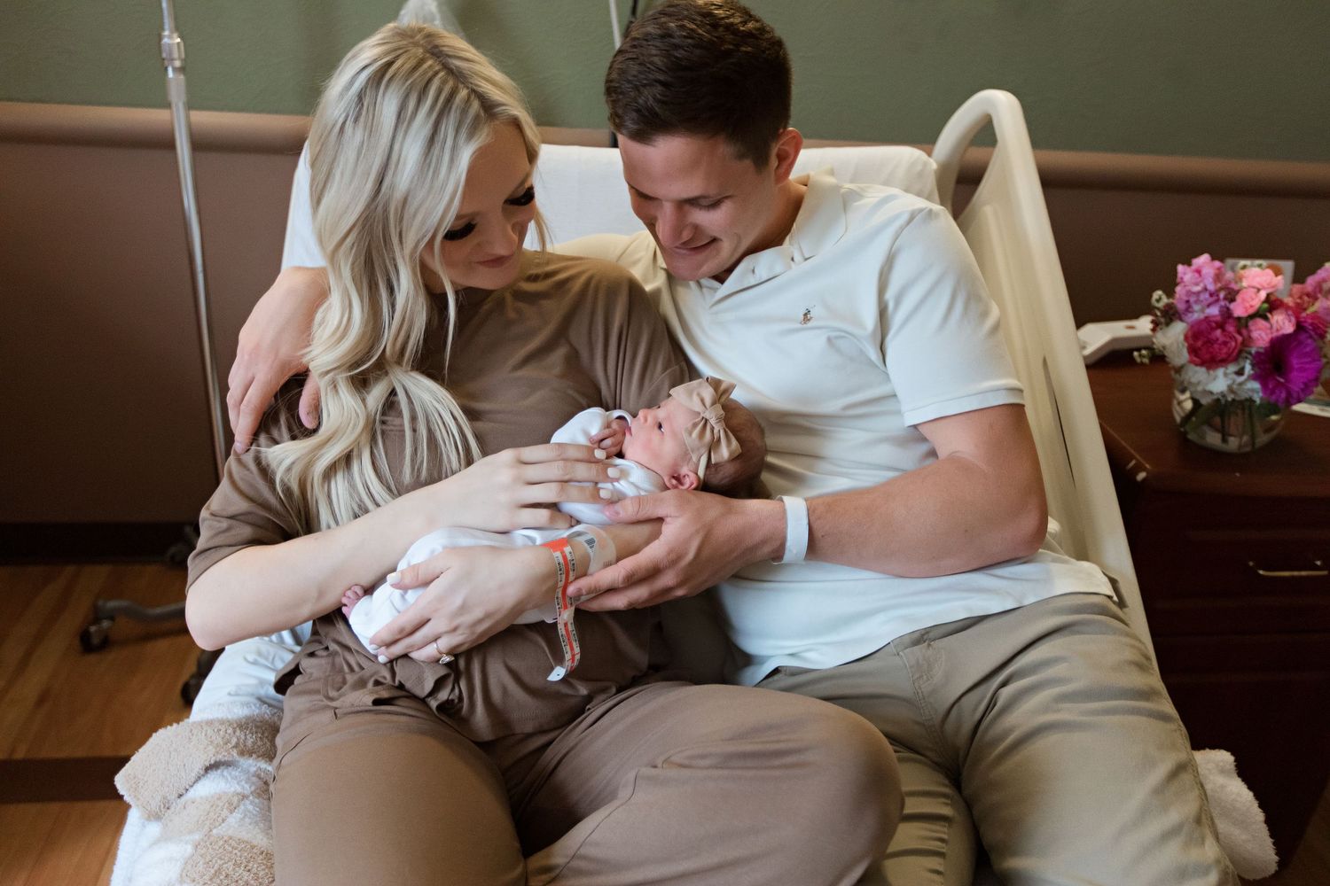 Parents holding and gazing lovingly at their newborn baby on bed during Fresh 48 session in Beaumont hospital.