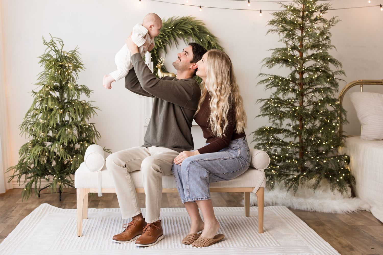 A series of romantic engagement photos showing couples embracing in front of Christmas trees in a cozy indoor setting.