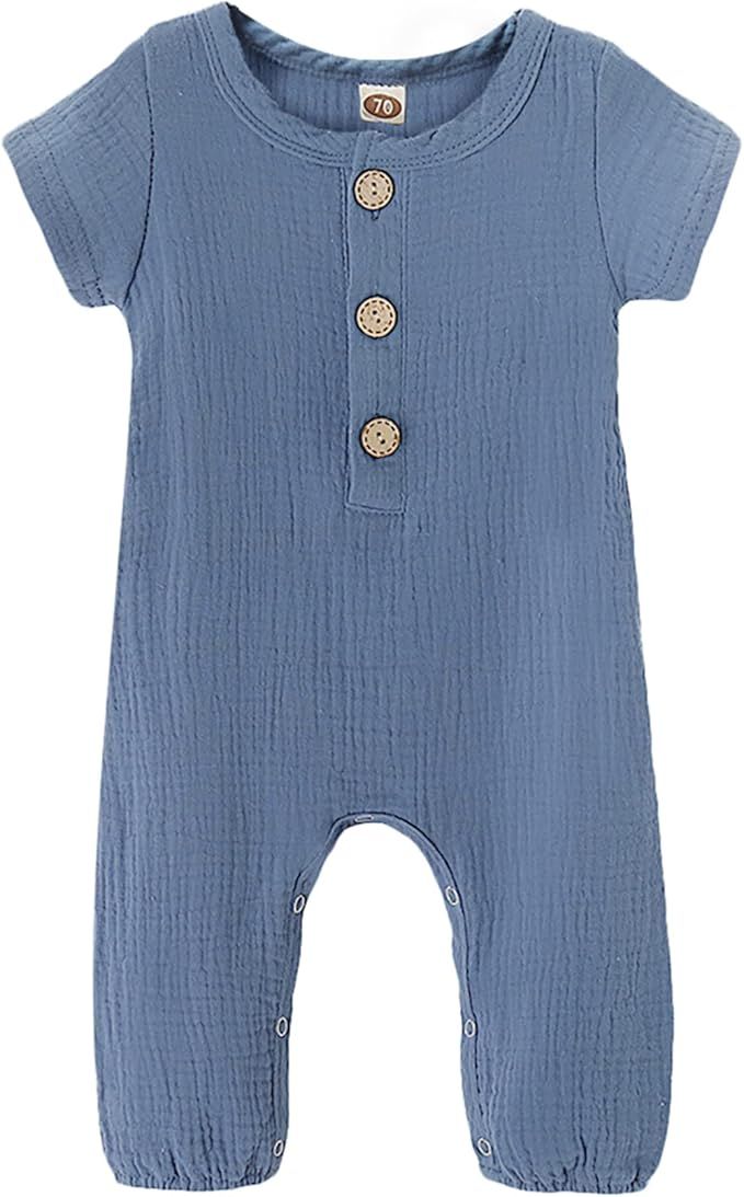 Blue muslin baby romper collection with decorative buttons and short sleeves in various sizes laid flat against white background.
