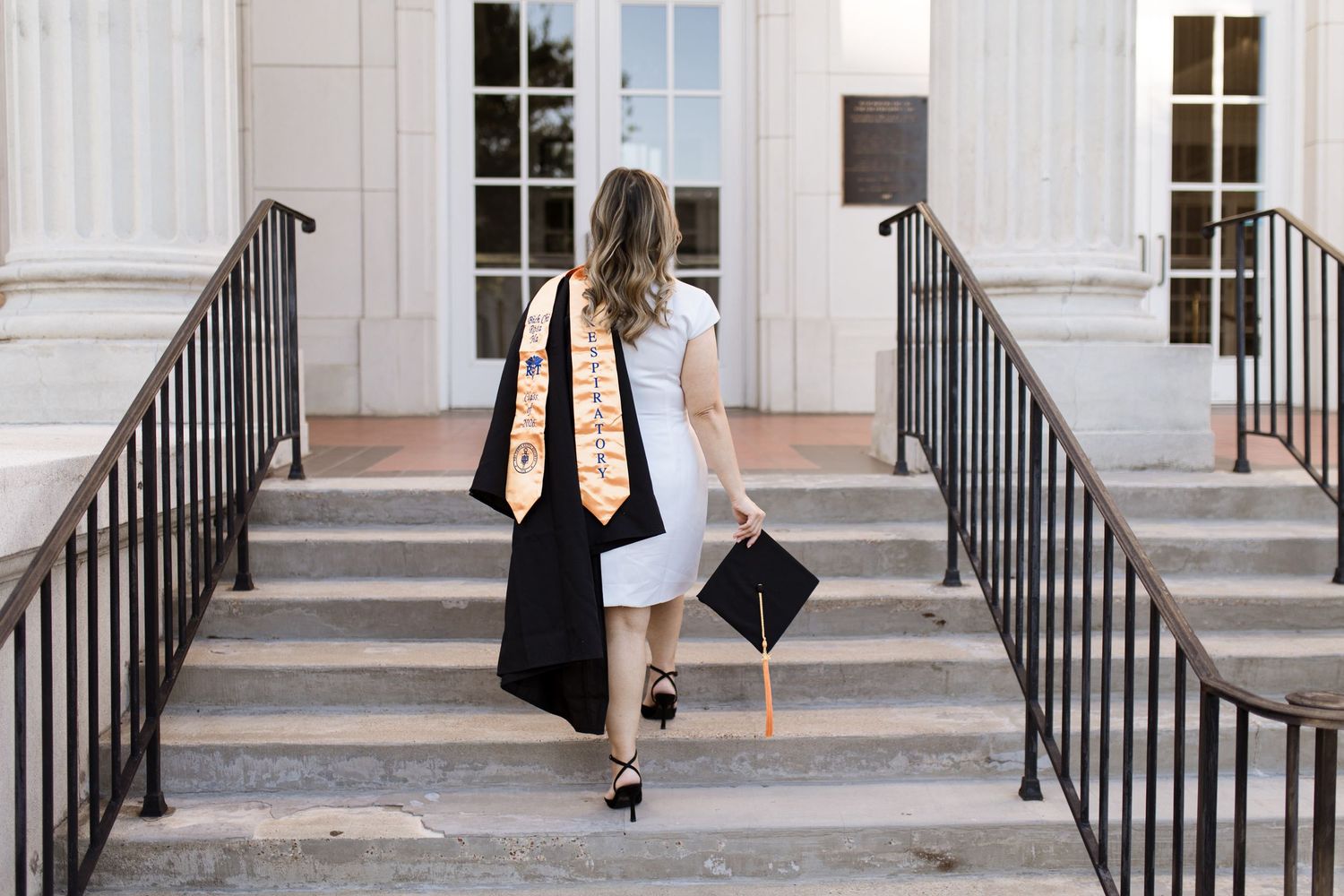 Graduating senior in white dress with cap and gown. Session with Bree Elle Photography Seniors by Alicia Stephenson in Beaumont, TX at Julie