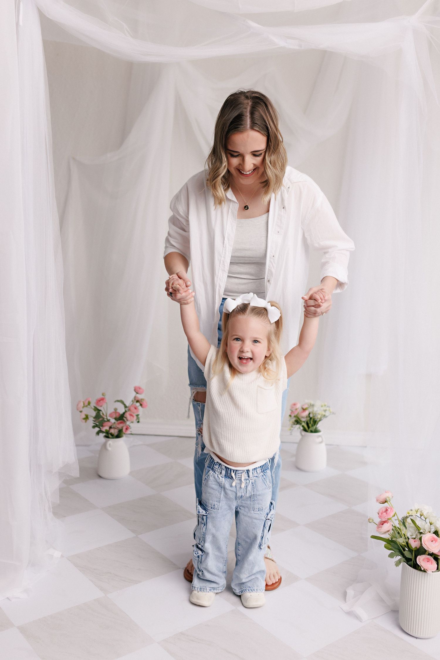Parent and toddler in matching white tops and jeans during mommy and me session with Bree Elle Photography in Port Neches, TX.