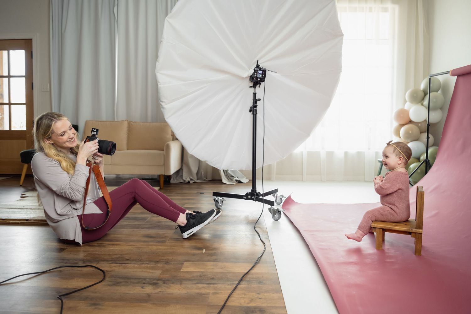 Professional photography studio setup with large umbrella light and equipment.