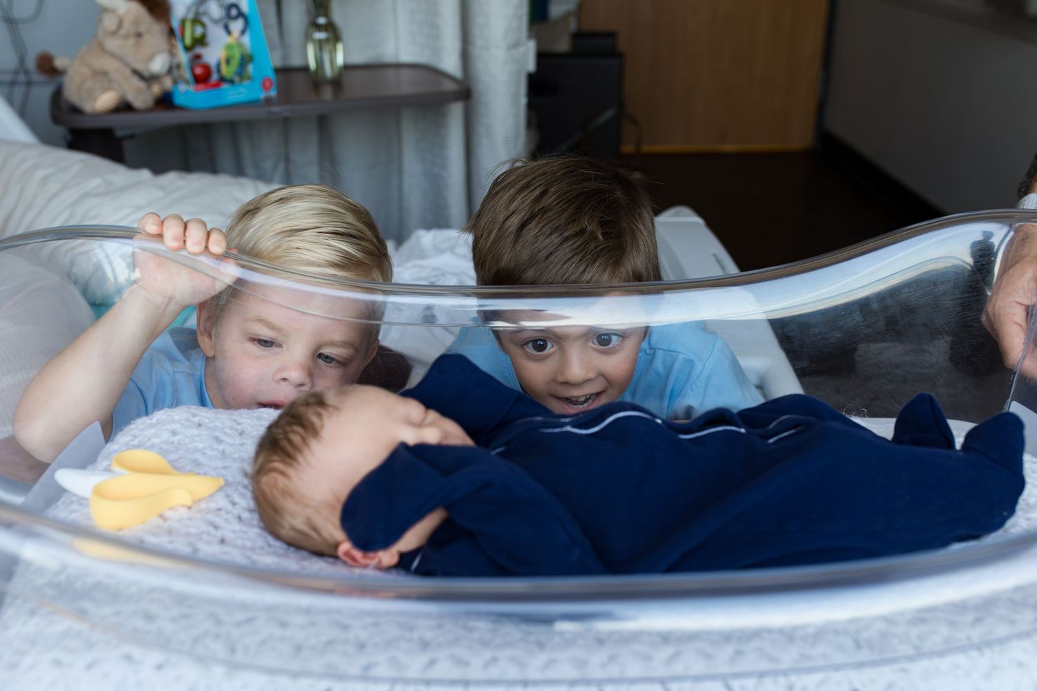 Older brothers meeting their newborn baby during Fresh 48 session in Beaumont, TX at St. Elizabeth with Bree Elle Photography.