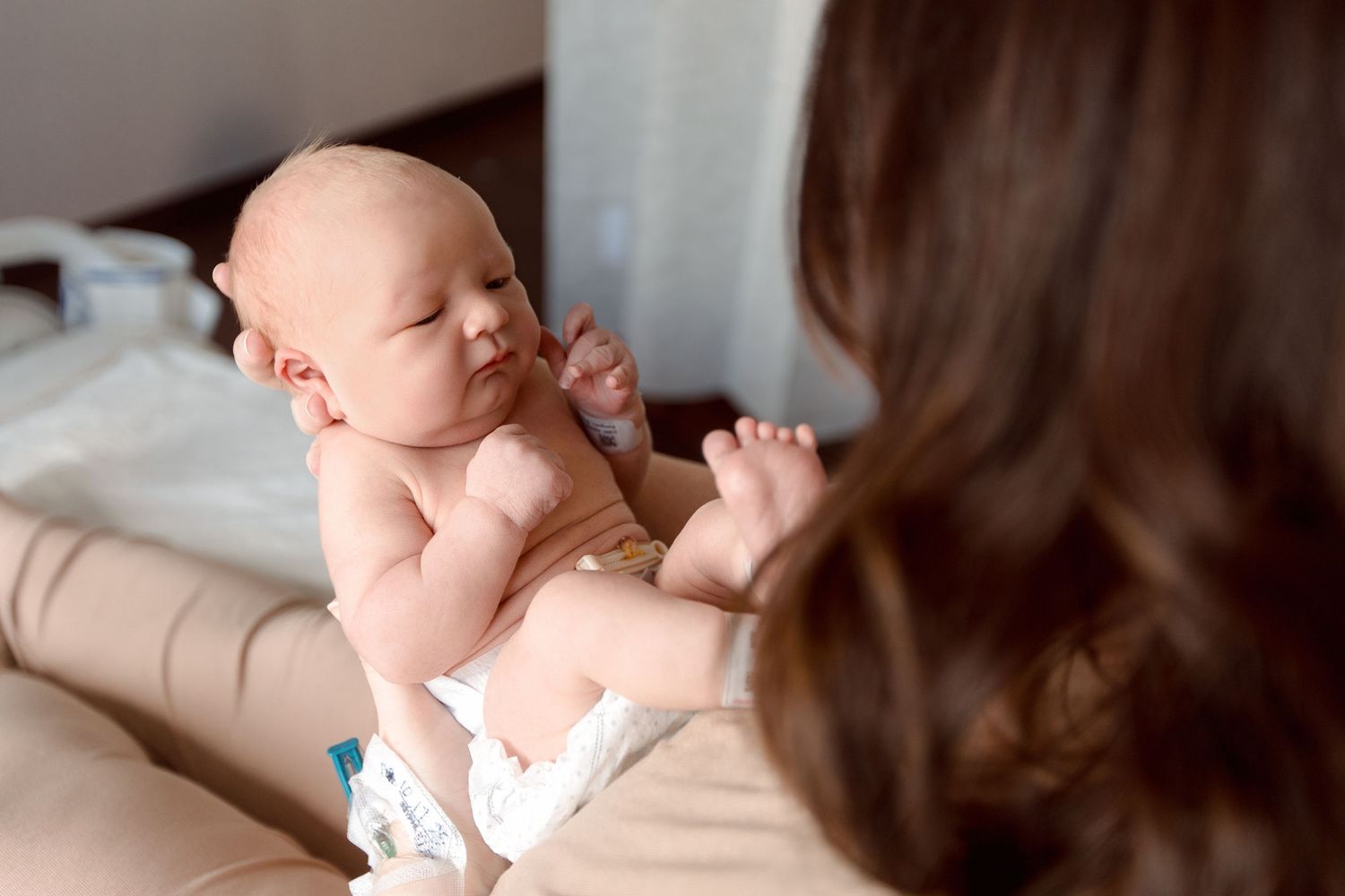 A parent and baby share tender moments while bonding during a gentle newborn photography session during Fresh 48 session in Beaumont.