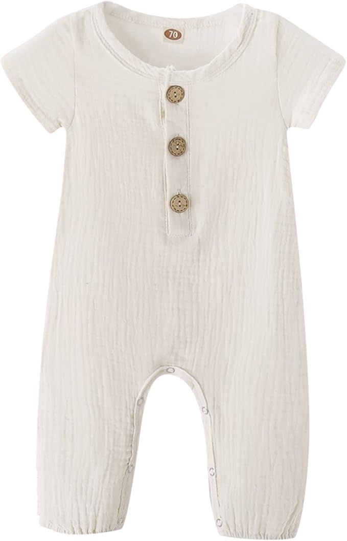 Three white cotton baby rompers with wooden button details arranged side by side showing different views of the garment.