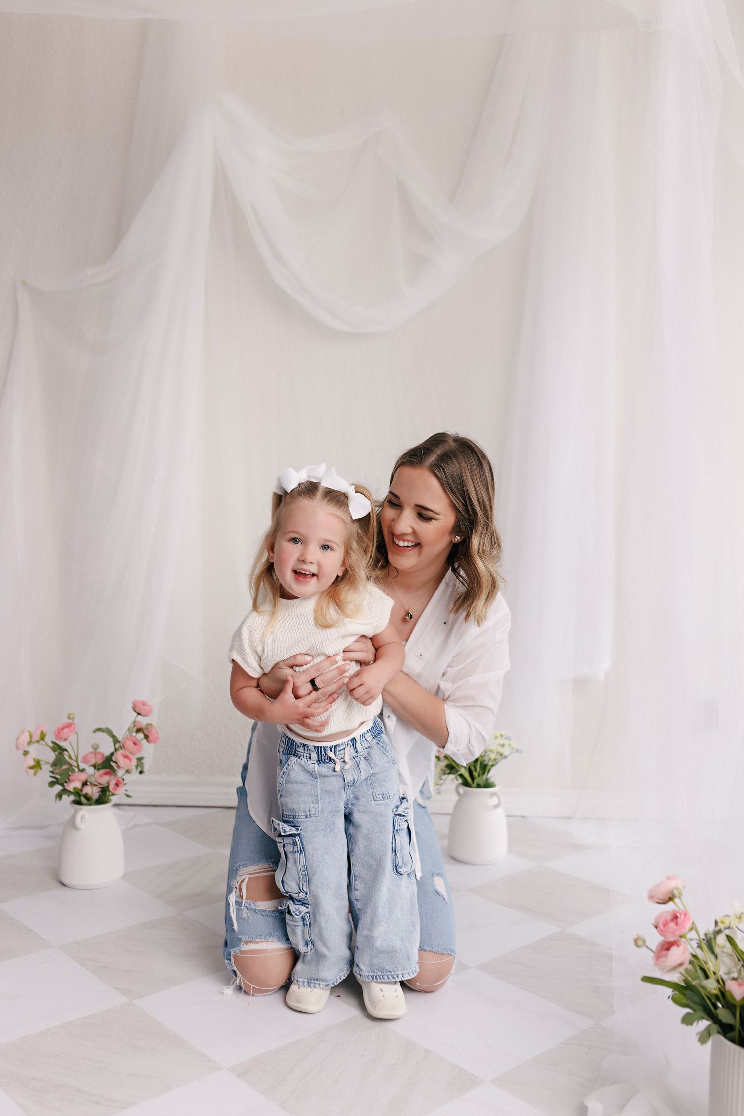 Parent and toddler in matching white tops and jeans during mommy and me session with Bree Elle Photography in Port Neches, TX.