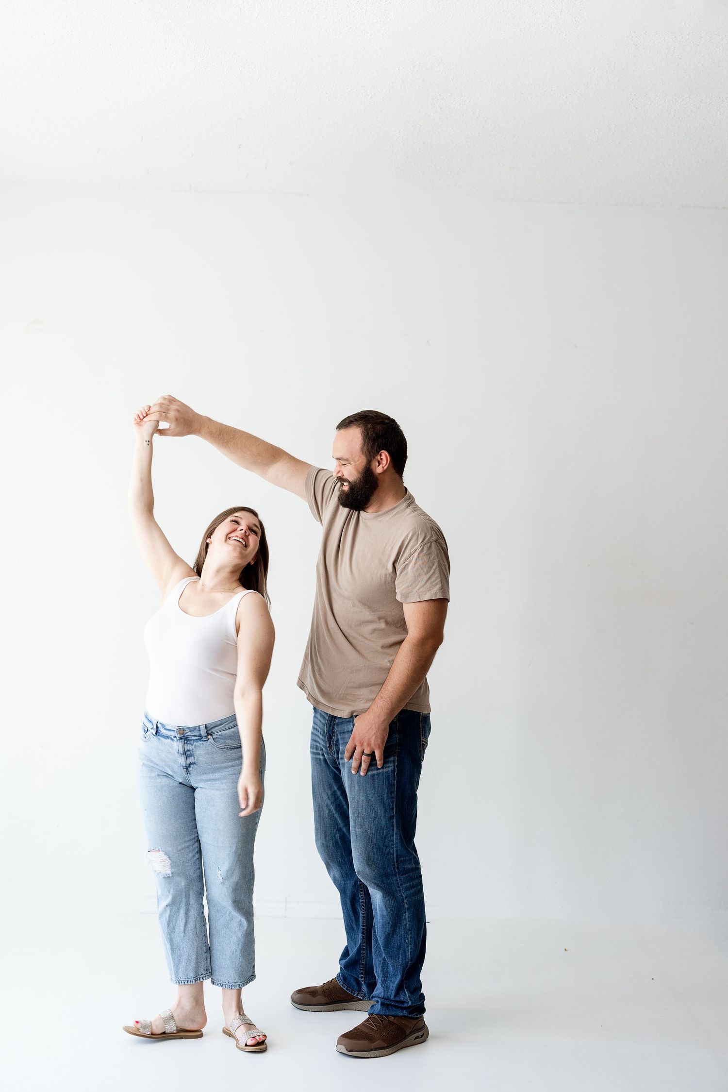 Three sequential shots of a couple dancing and posing playfully against a white background.