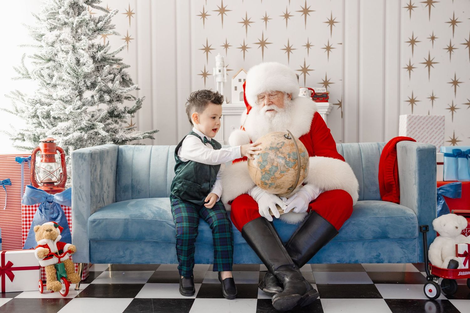 Two people sit on a blue couch in a festive room decorated with gold stars and a Christmas tree.