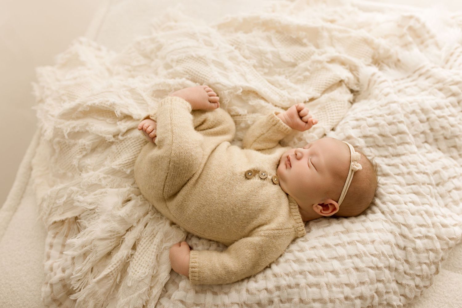 Series of photos showing sleeping newborn baby in neutral tones on white textured bedding.