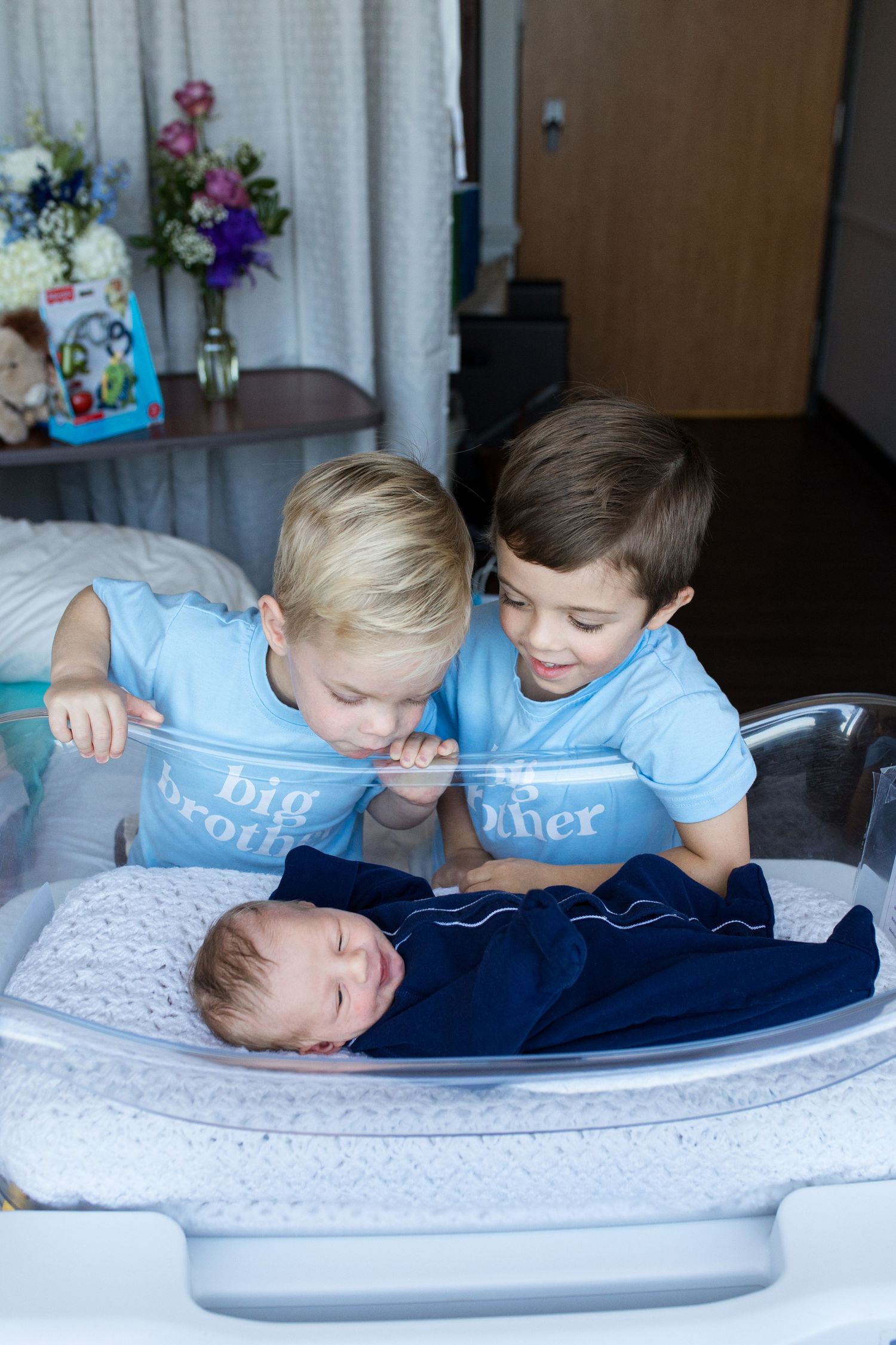 Older brothers meeting their newborn baby during Fresh 48 session in Beaumont, TX at St. Elizabeth with Bree Elle Photography.