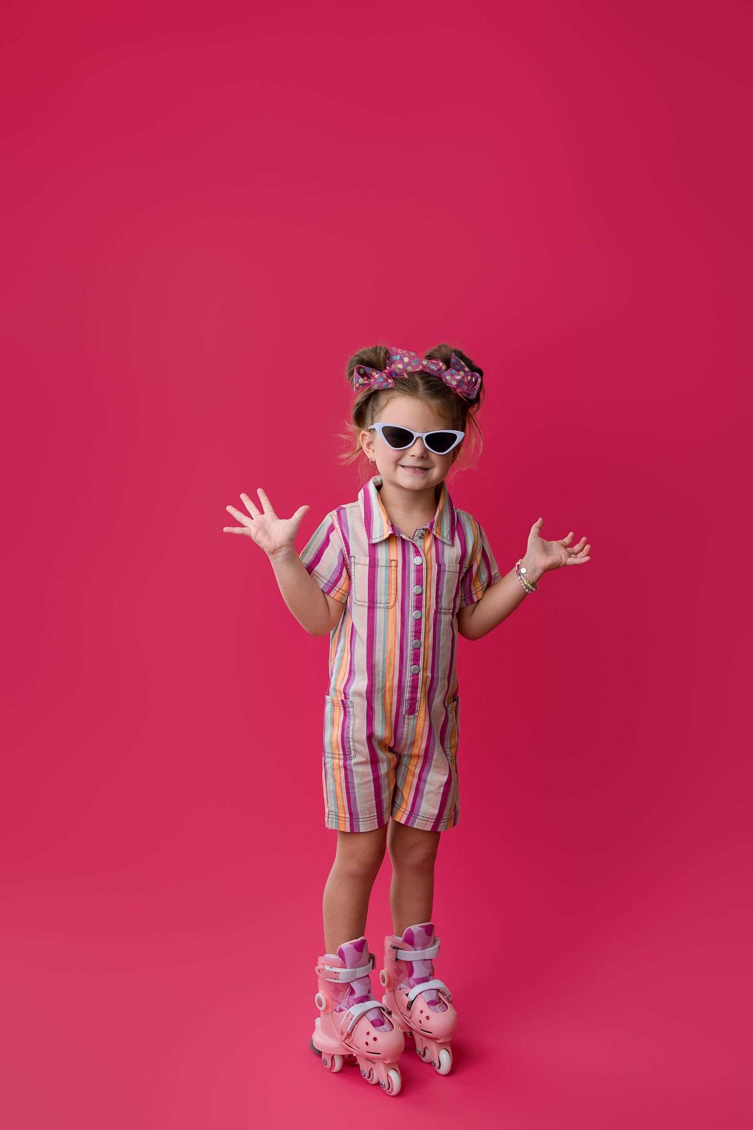 A figure wearing sunglasses and pink striped outfit strikes playful poses on roller skates against a hot pink backdrop.