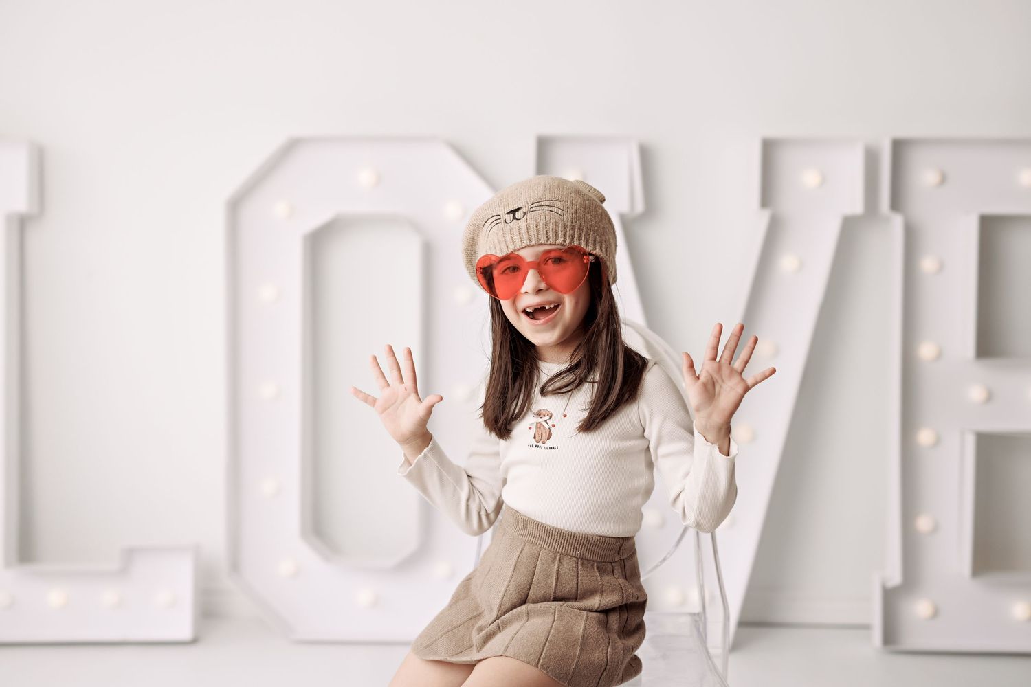 Portrait session against a white wall with block letters.