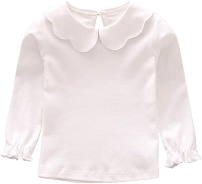 White children's long sleeve shirts with Peter Pan collars and ruffle details displayed in a row.