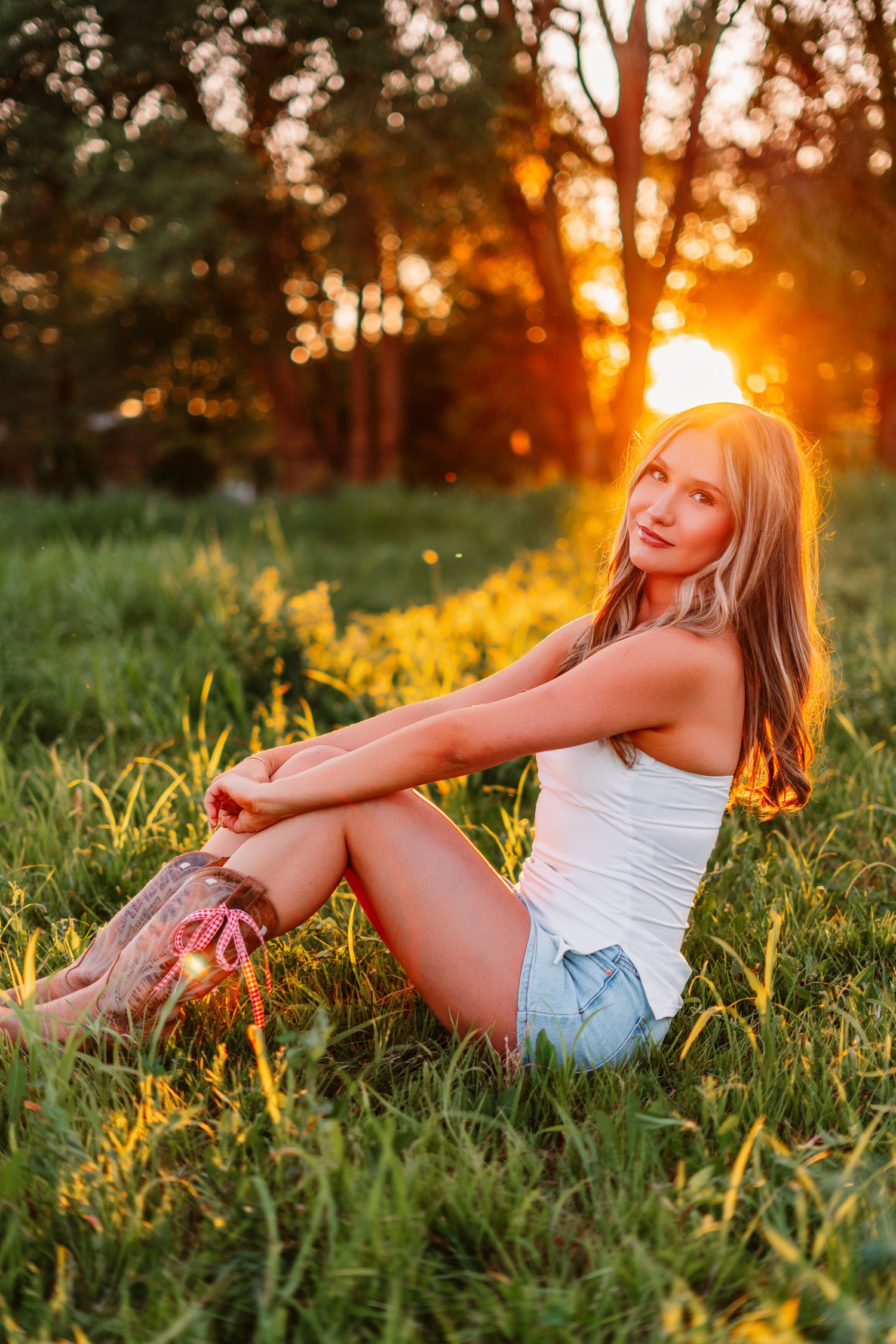 Summer sunset portrait session in grass field with golden backlight.