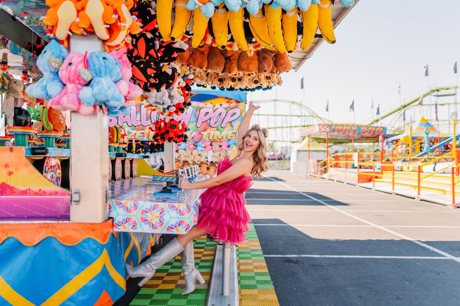 Carnival themed portrait session with bright fairground games and decorative elements in background.