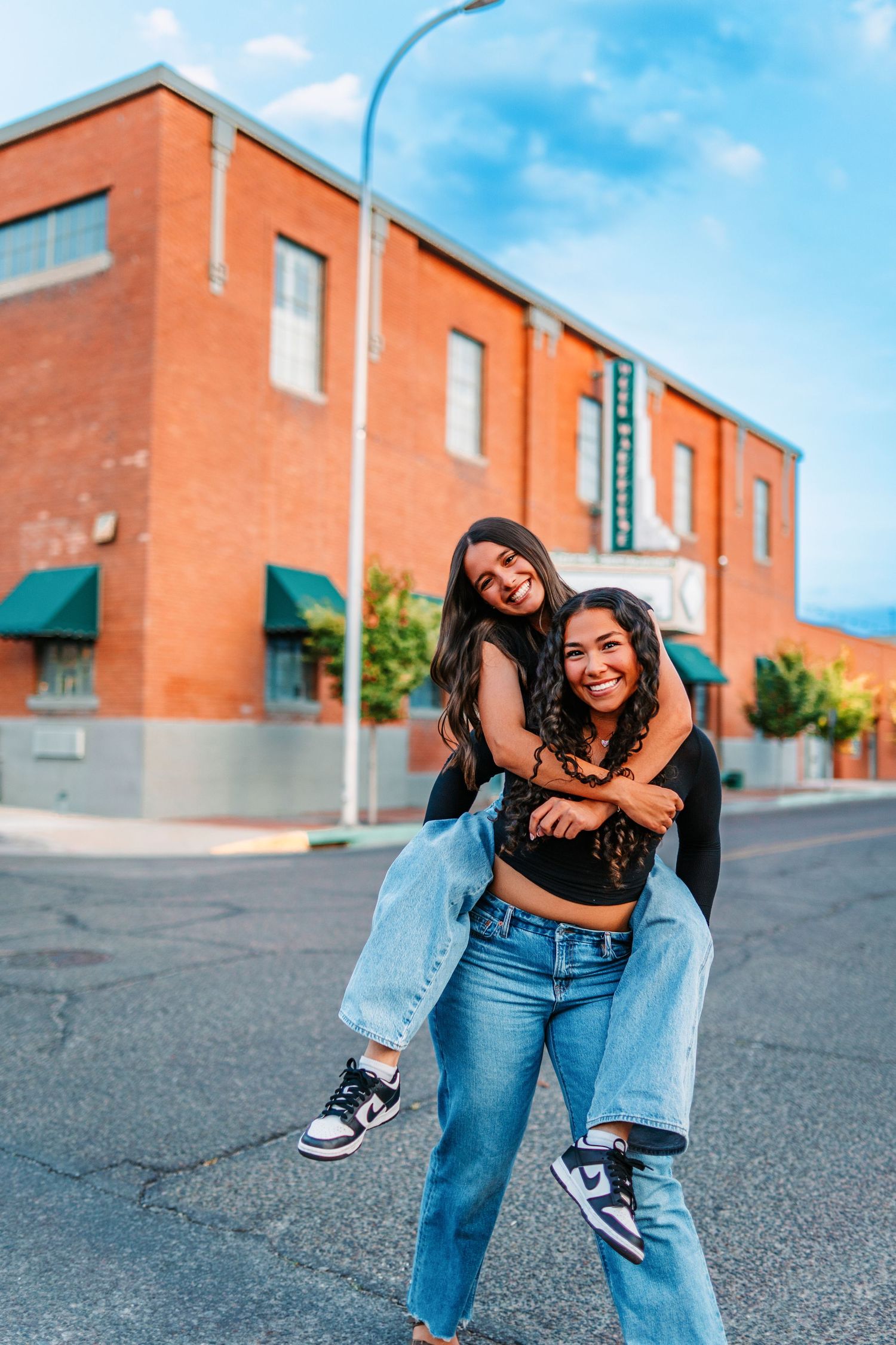 Two friends in denim having fun and laughing in urban setting with brick buildings.varsity jacket
cheer uniform
soccer ball
softball bat