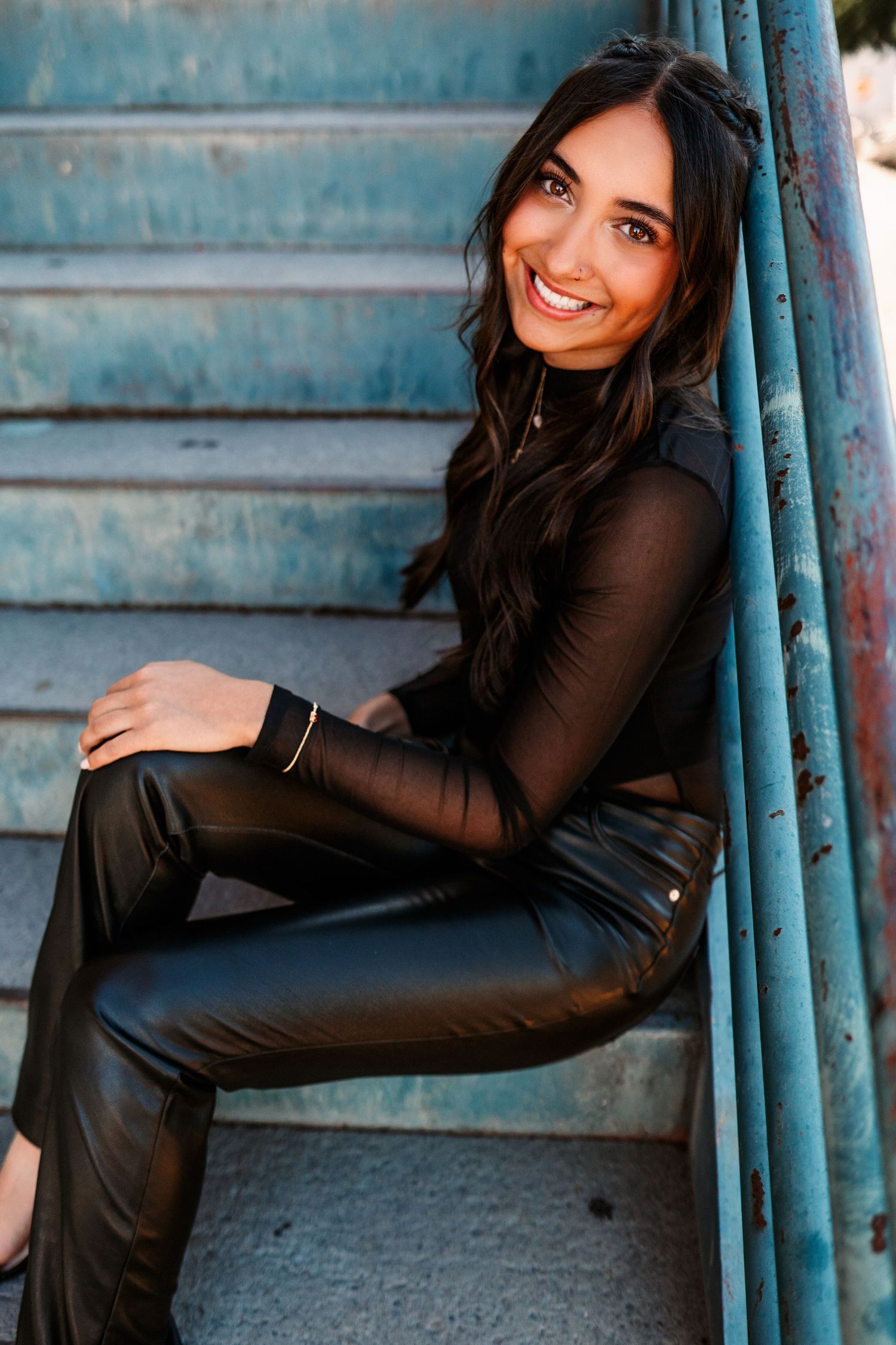 Urban portrait series on blue stairs showing casual poses in black outfit.