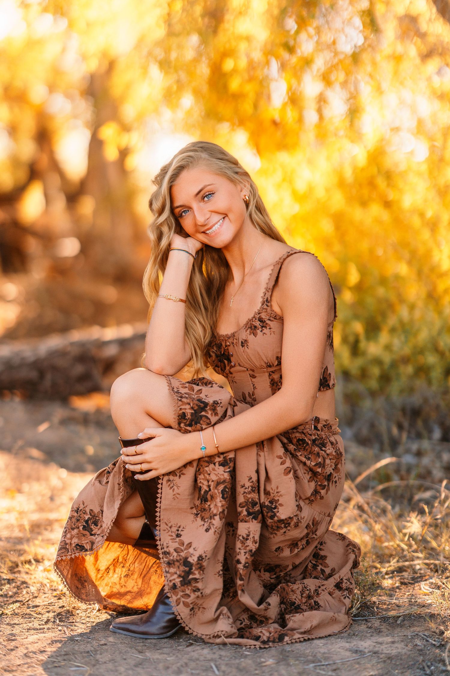 Autumn portrait in brown floral dress against golden bokeh background.