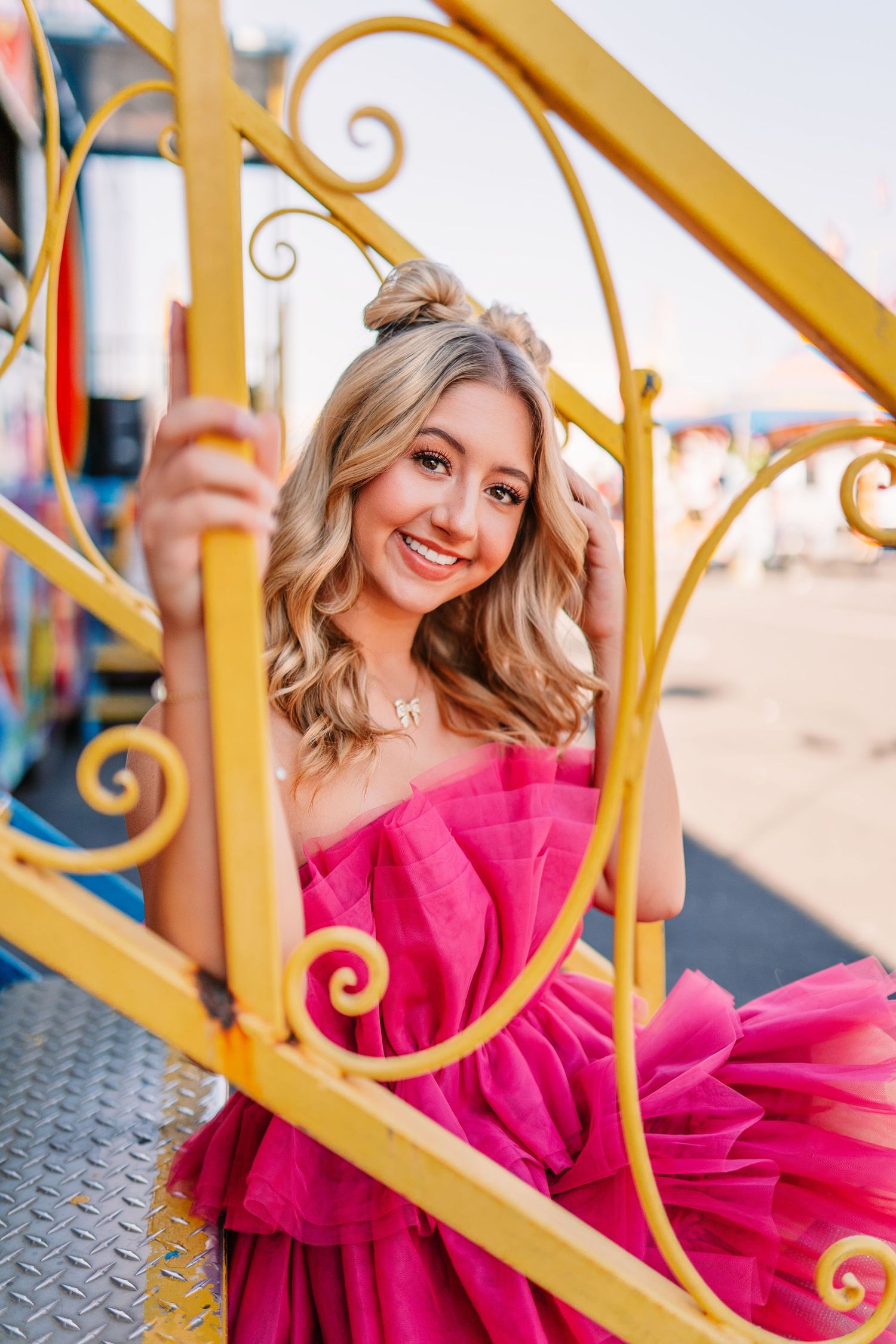 Decorative yellow carnival railing frames a festive carnival scene.