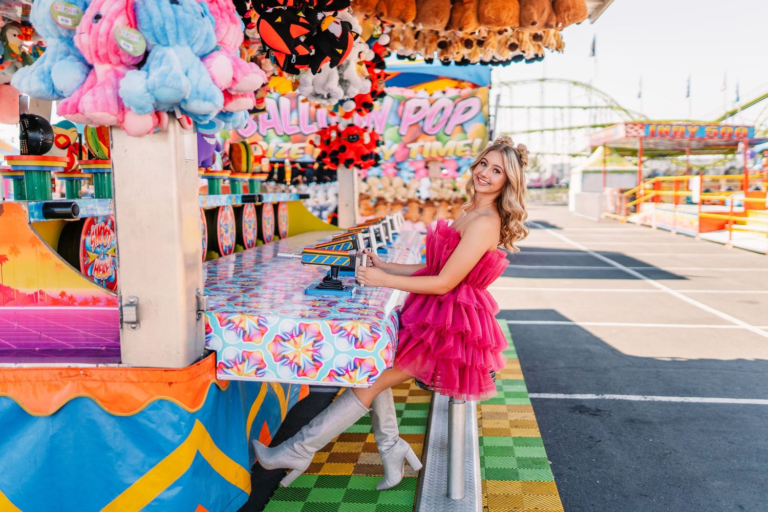 Vibrant carnival scene with pink and blue decorations and colorful gaming stalls.