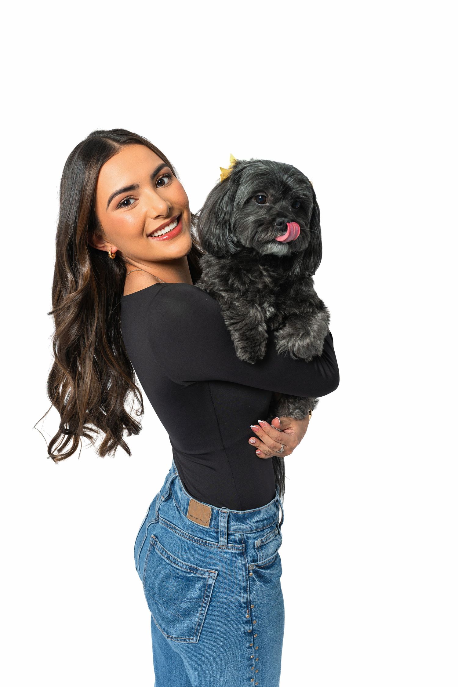 Playful series with black puppy and denim outfit against white background.