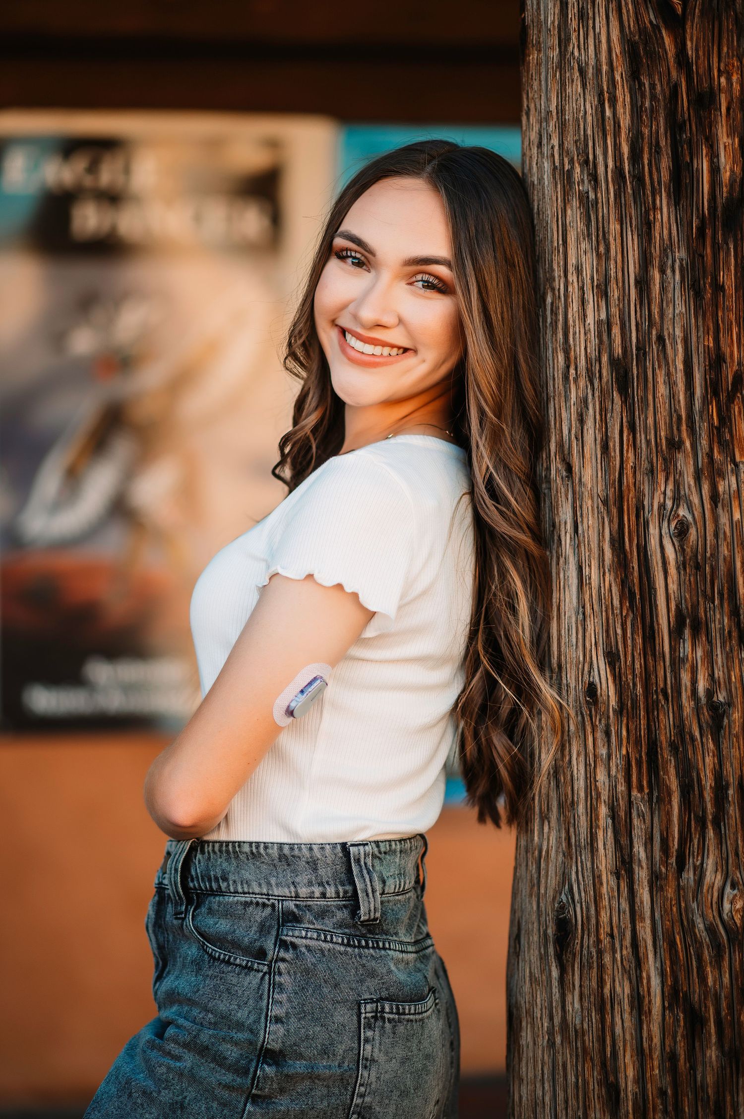 Casual portraits against wooden wall texture in denim and white outfit.