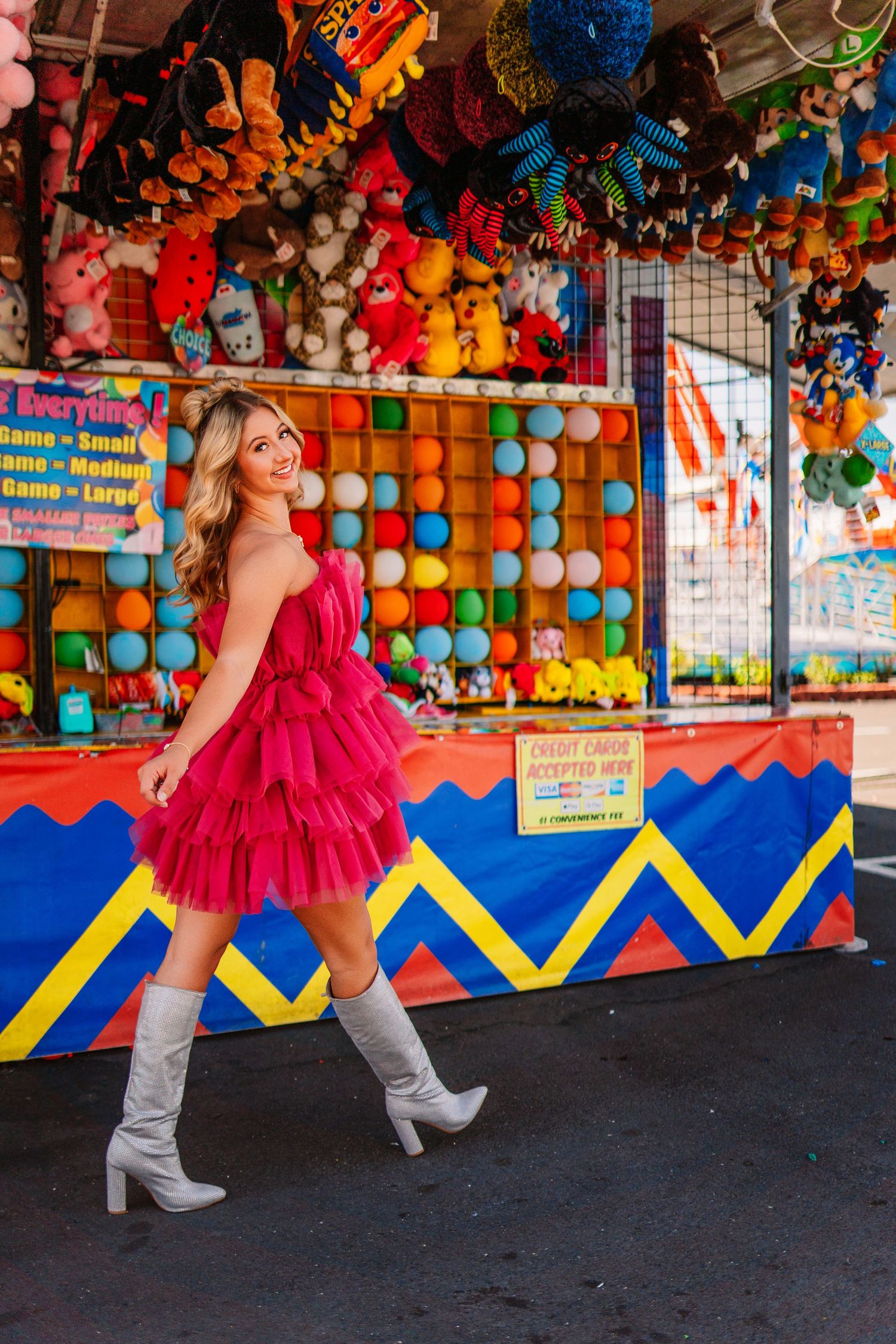 Playful carnival photoshoot featuring bright stuffed animals and geometric patterns.