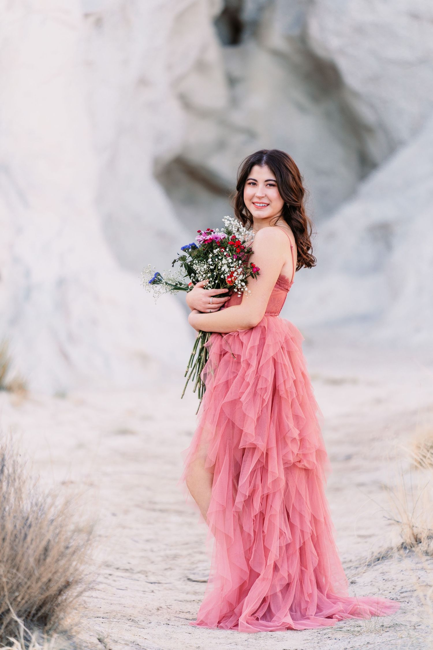 Portrait session in flowing pink gown against white rock formations.