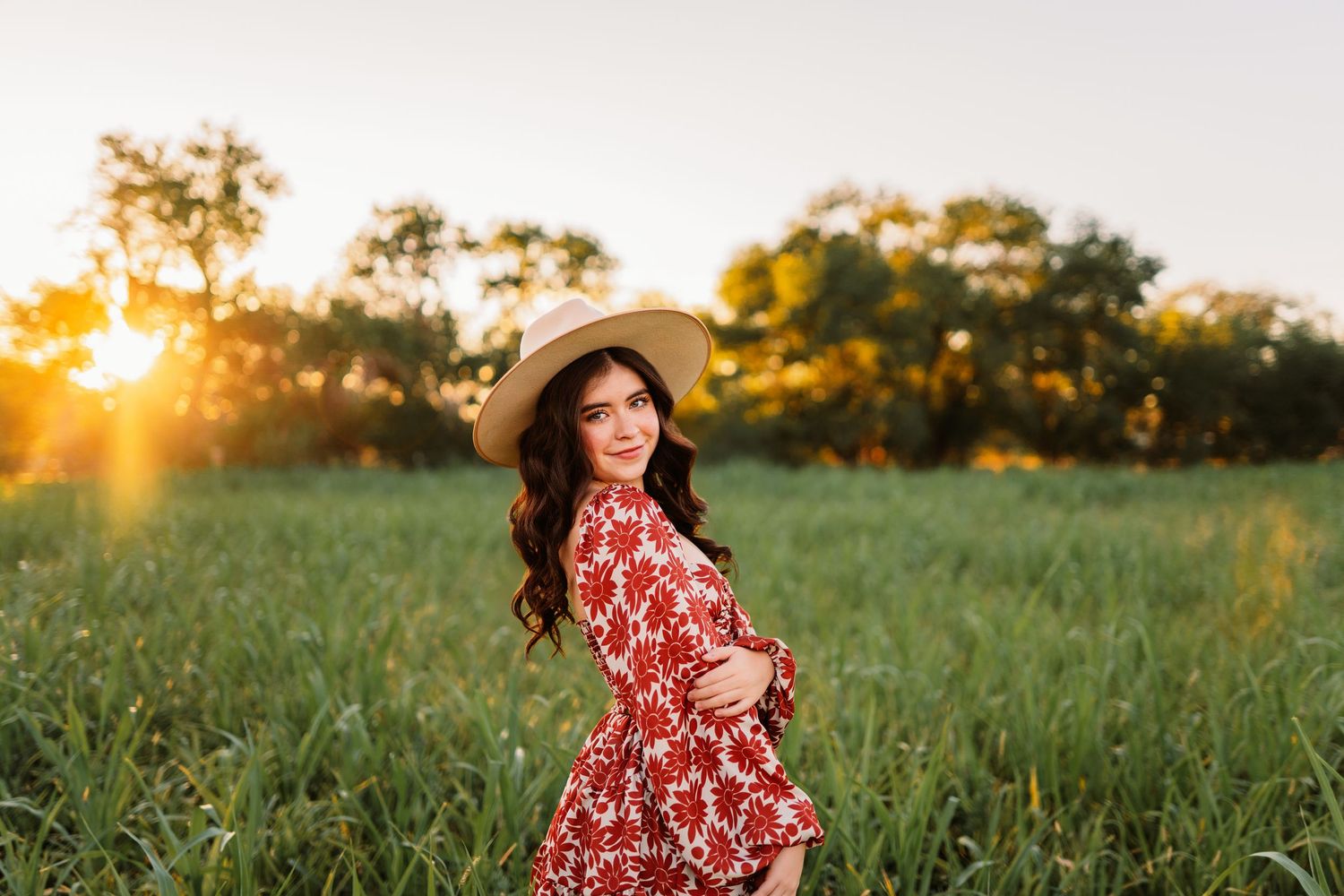 Person in a floral dress twirls joyfully in a sunlit field during golden hour. senior portrait
high school senior
senior photos
senior sessi