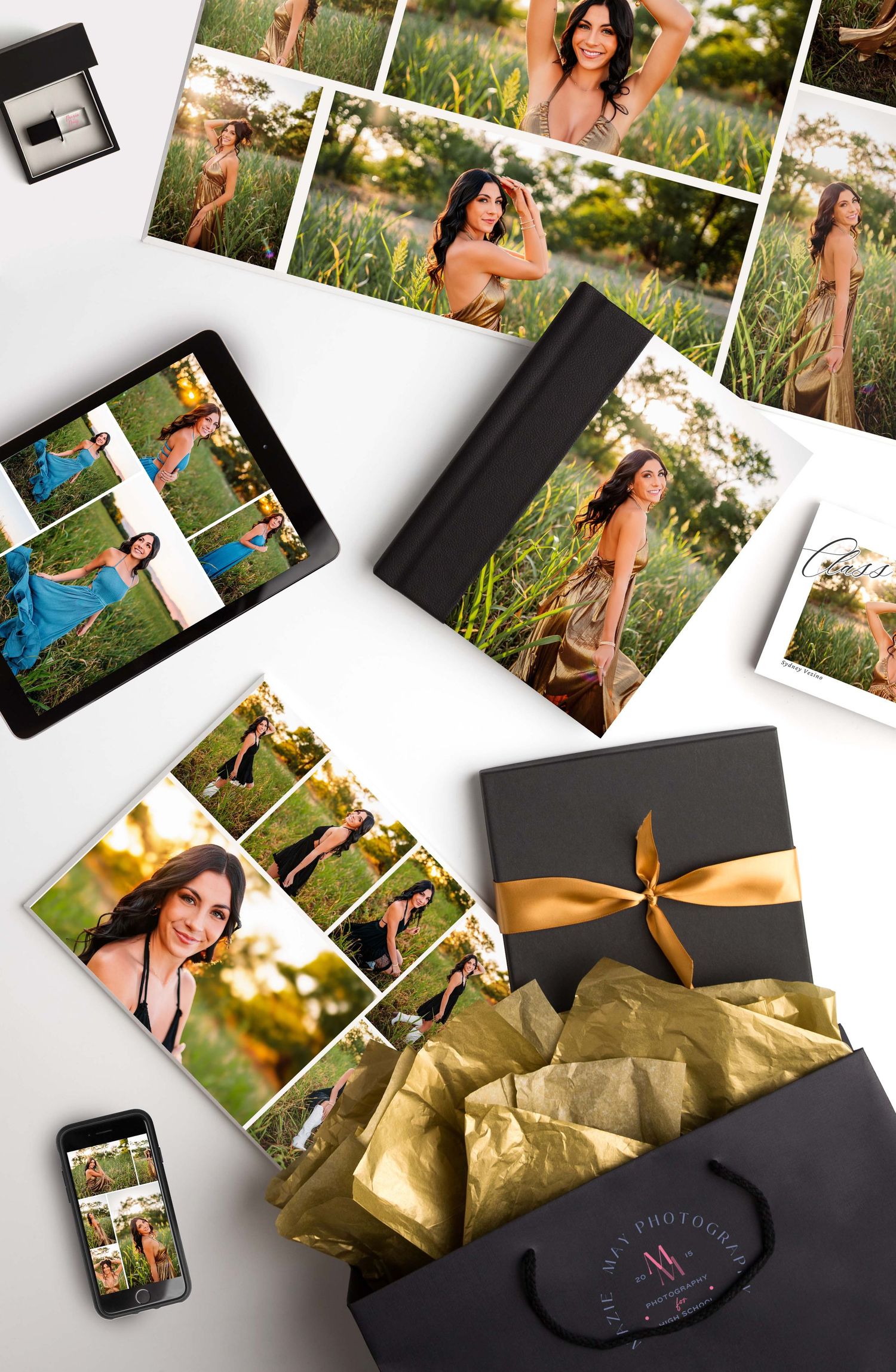 Photo prints and black gift boxes with gold and white tissue paper arranged on white background.