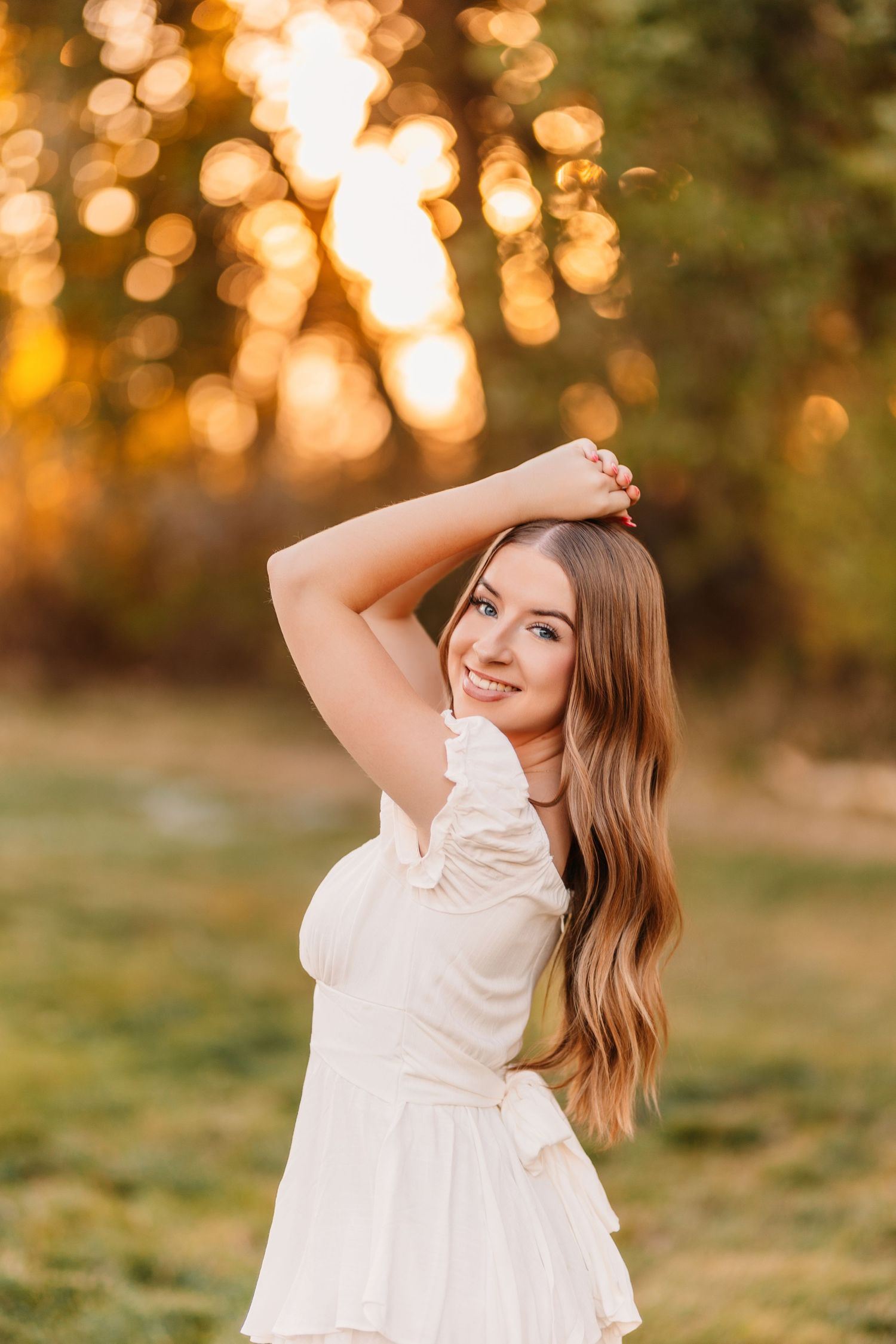 Dreamy sunset portraits in a white dress with glowing golden bokeh background.