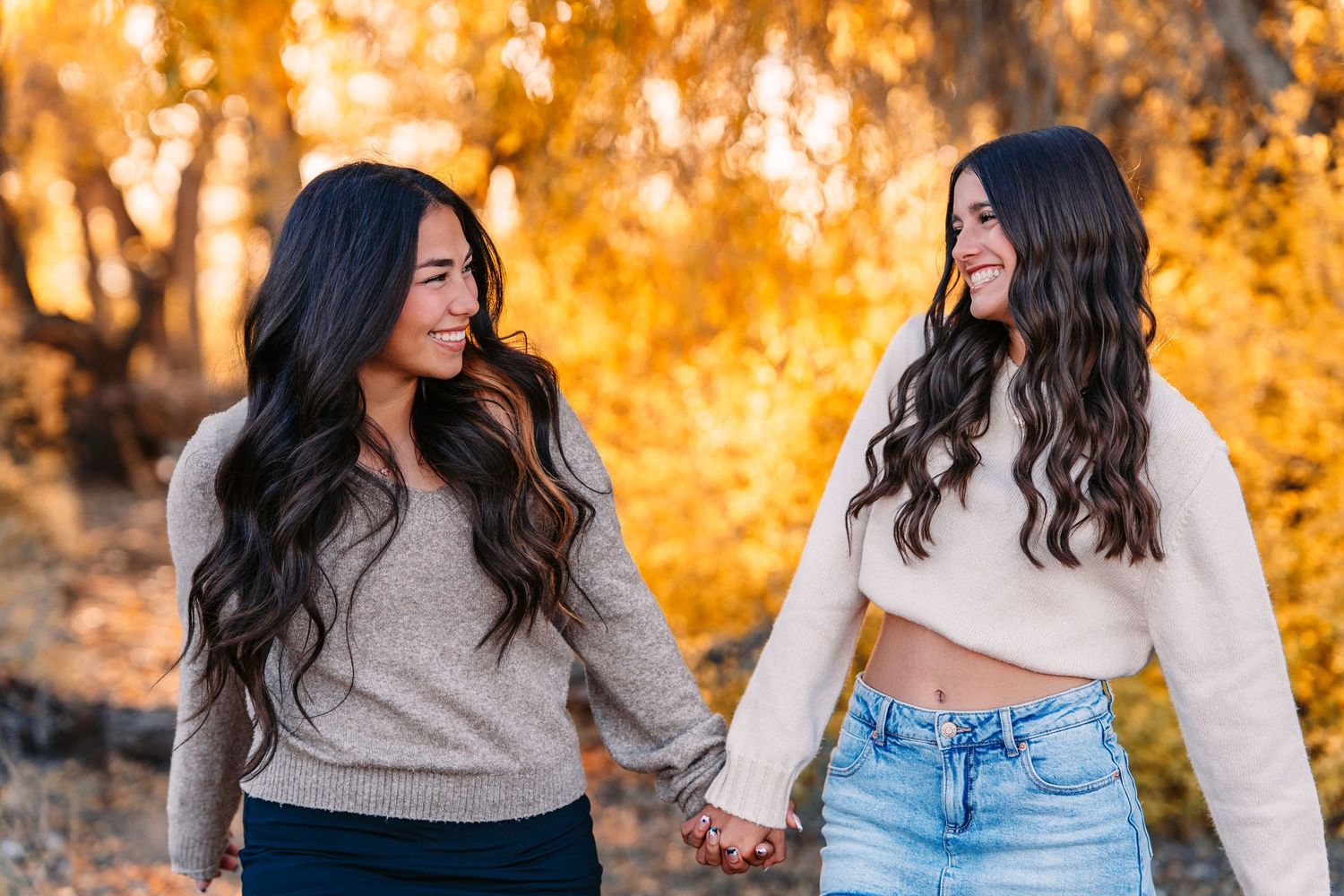 Friends walking together in casual outfits against golden autumn trees.
