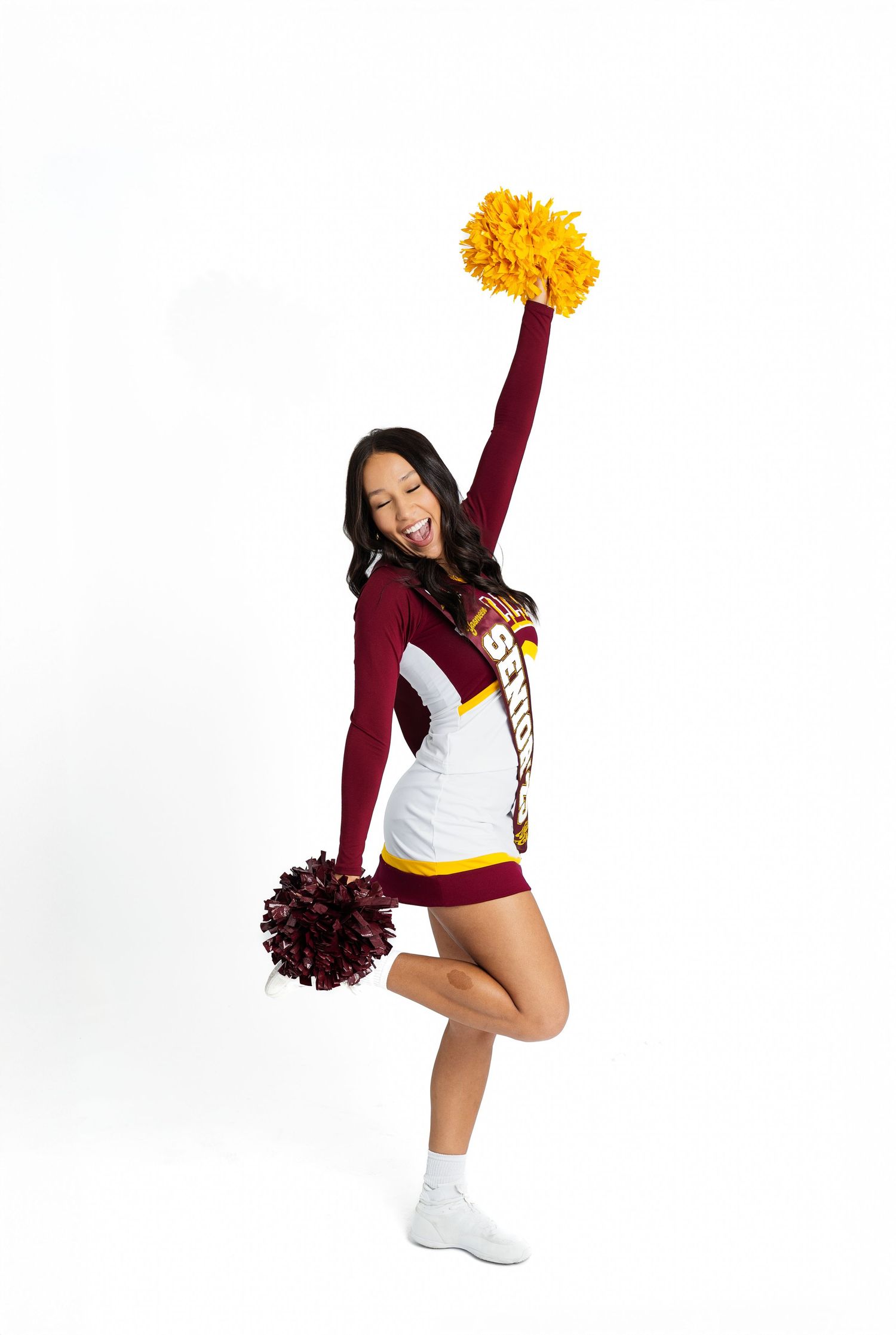 Cheerleader performing dynamic poses with pom-poms in maroon and gold uniform.varsity jacket
cheer uniform
soccer ball
softball bat