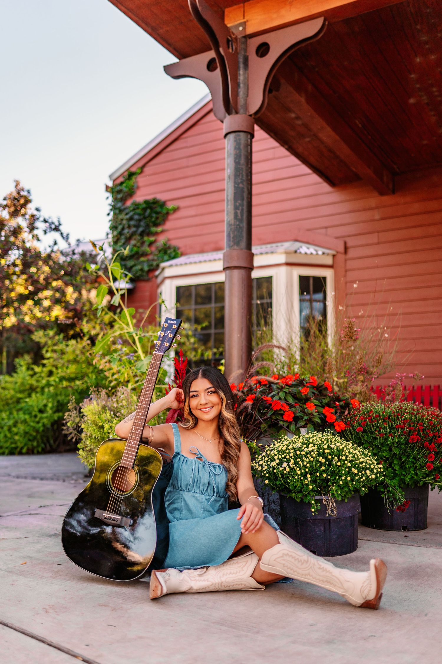 Casual portrait session outside coral-colored building with hanging flower baskets.