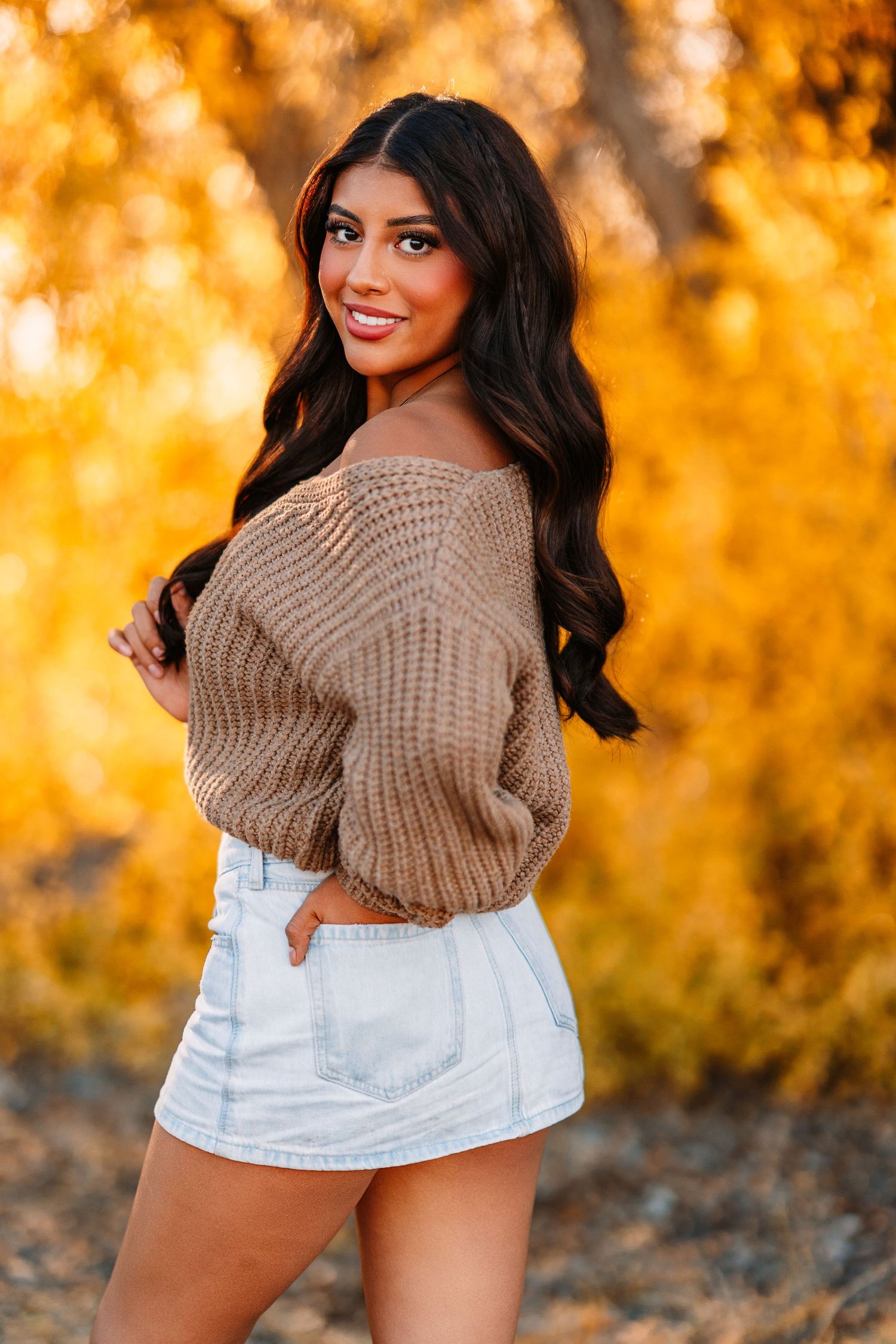 Autumn fashion photography with warm orange lighting and cozy knit sweater.