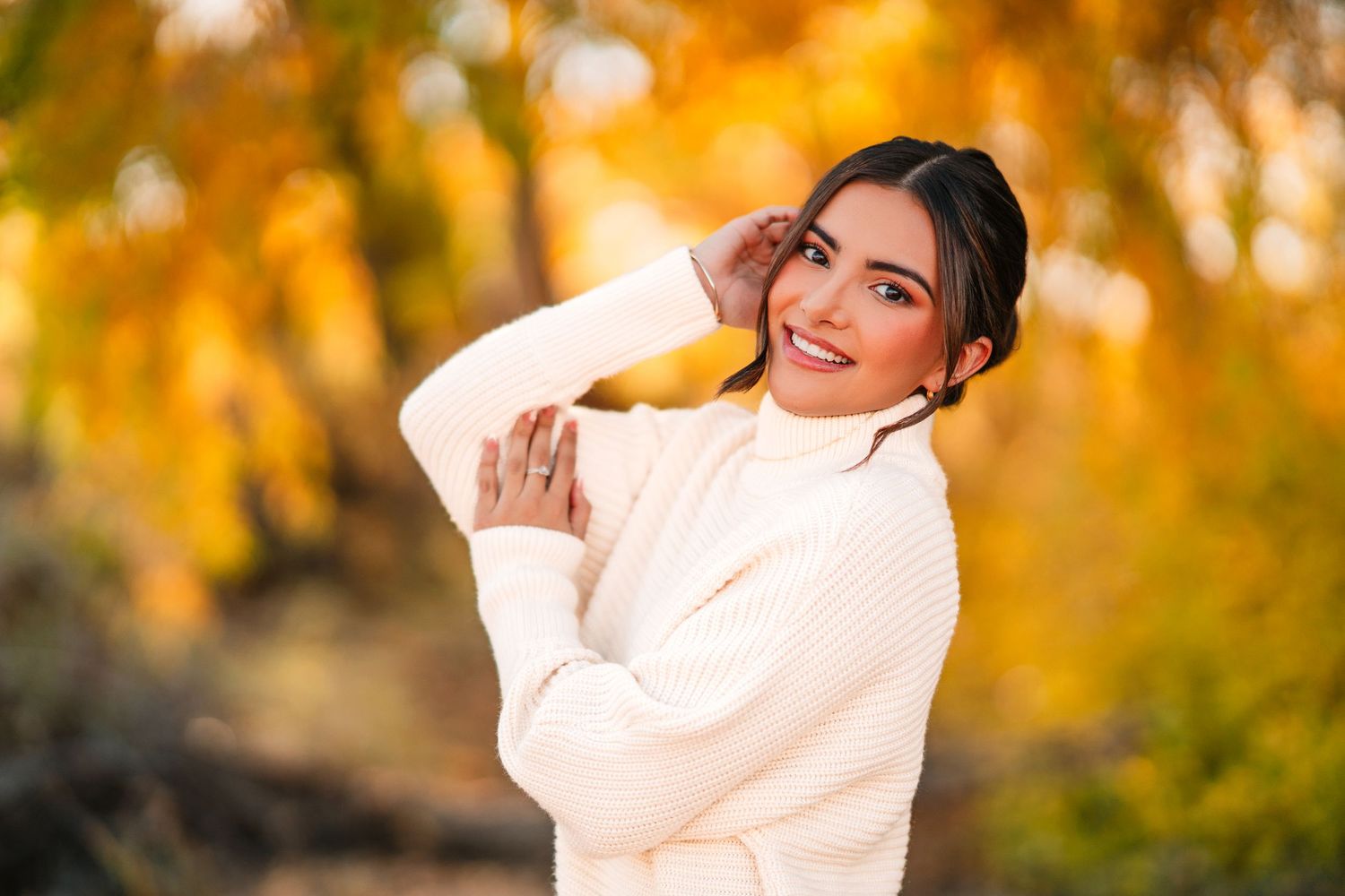 Autumn outdoor portraits in cream sweater with golden sunlit background.