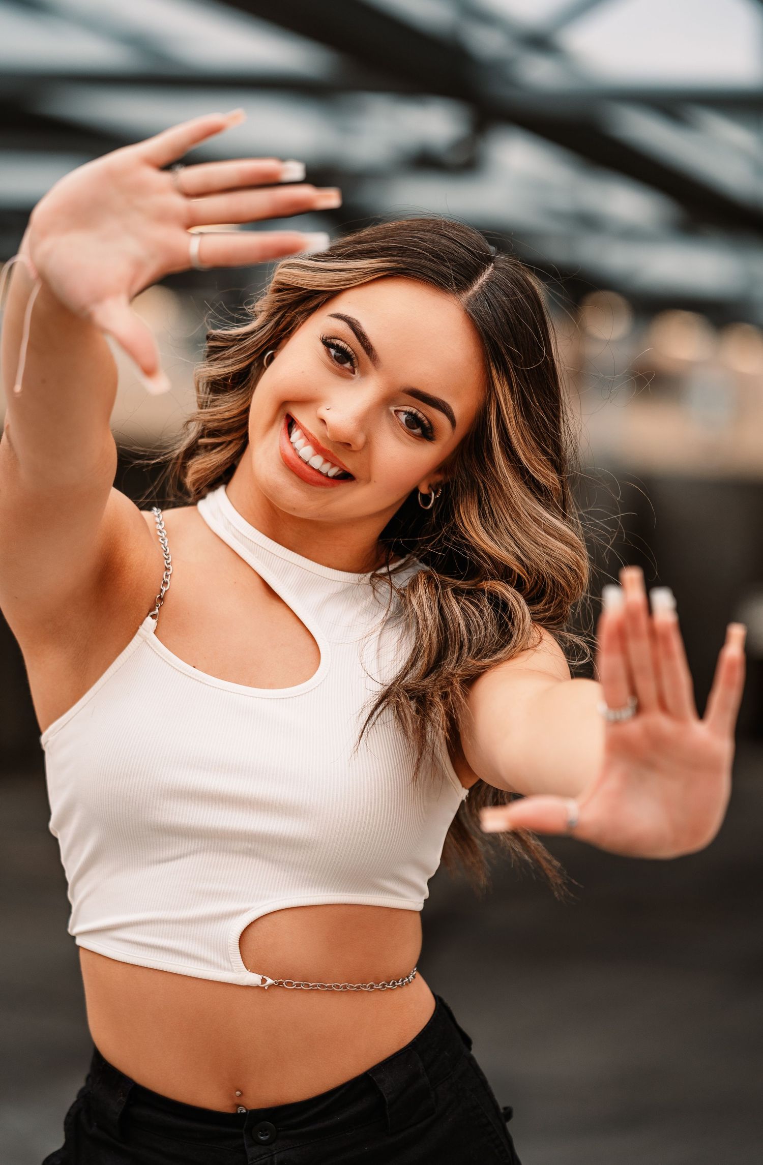 Dance-inspired poses in a white crop top against an industrial background with dramatic lighting.portraits, images, session, photo shoot